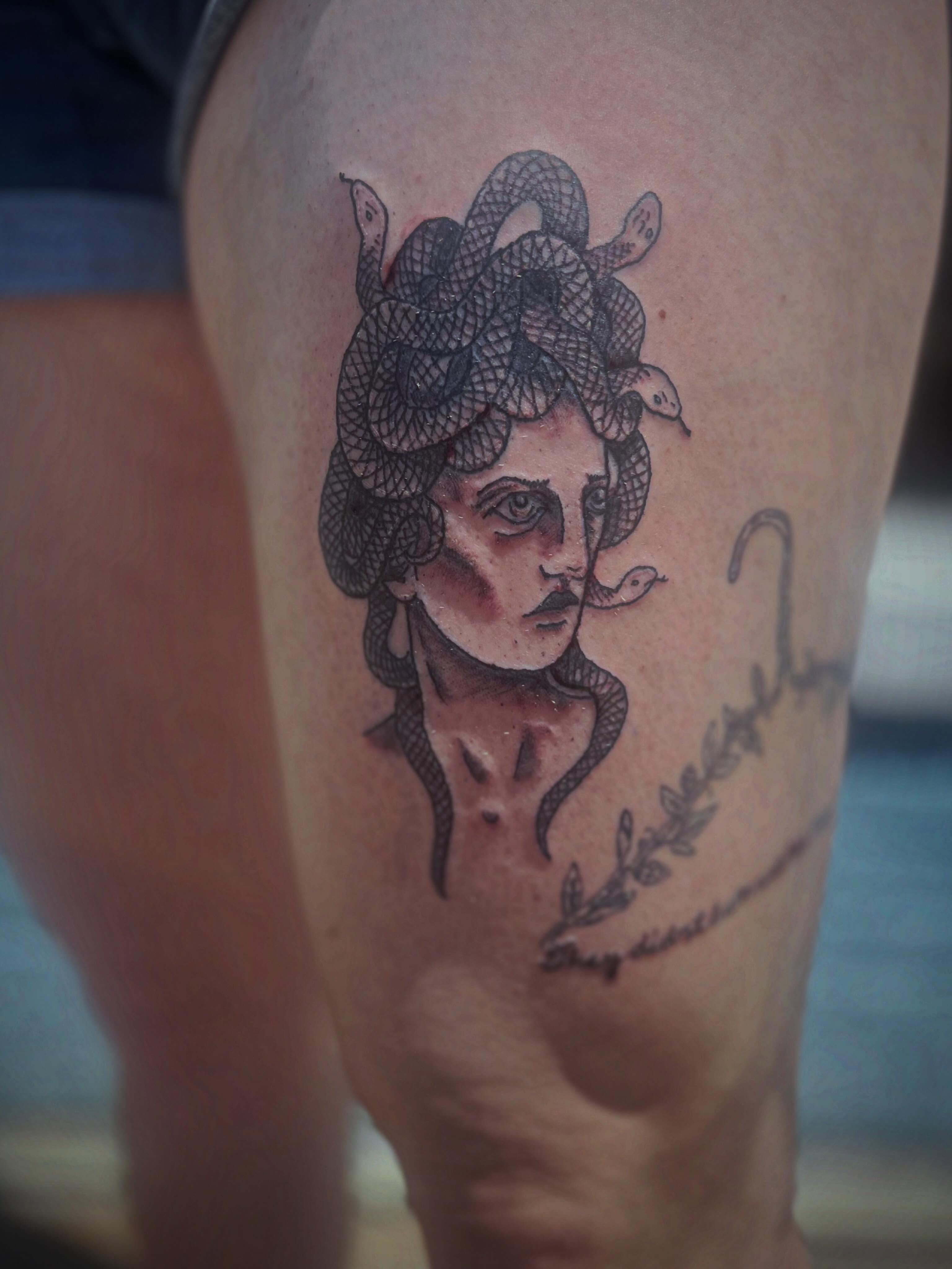 Medusa black and grey tattoo on the thigh by Rafaela Lopez