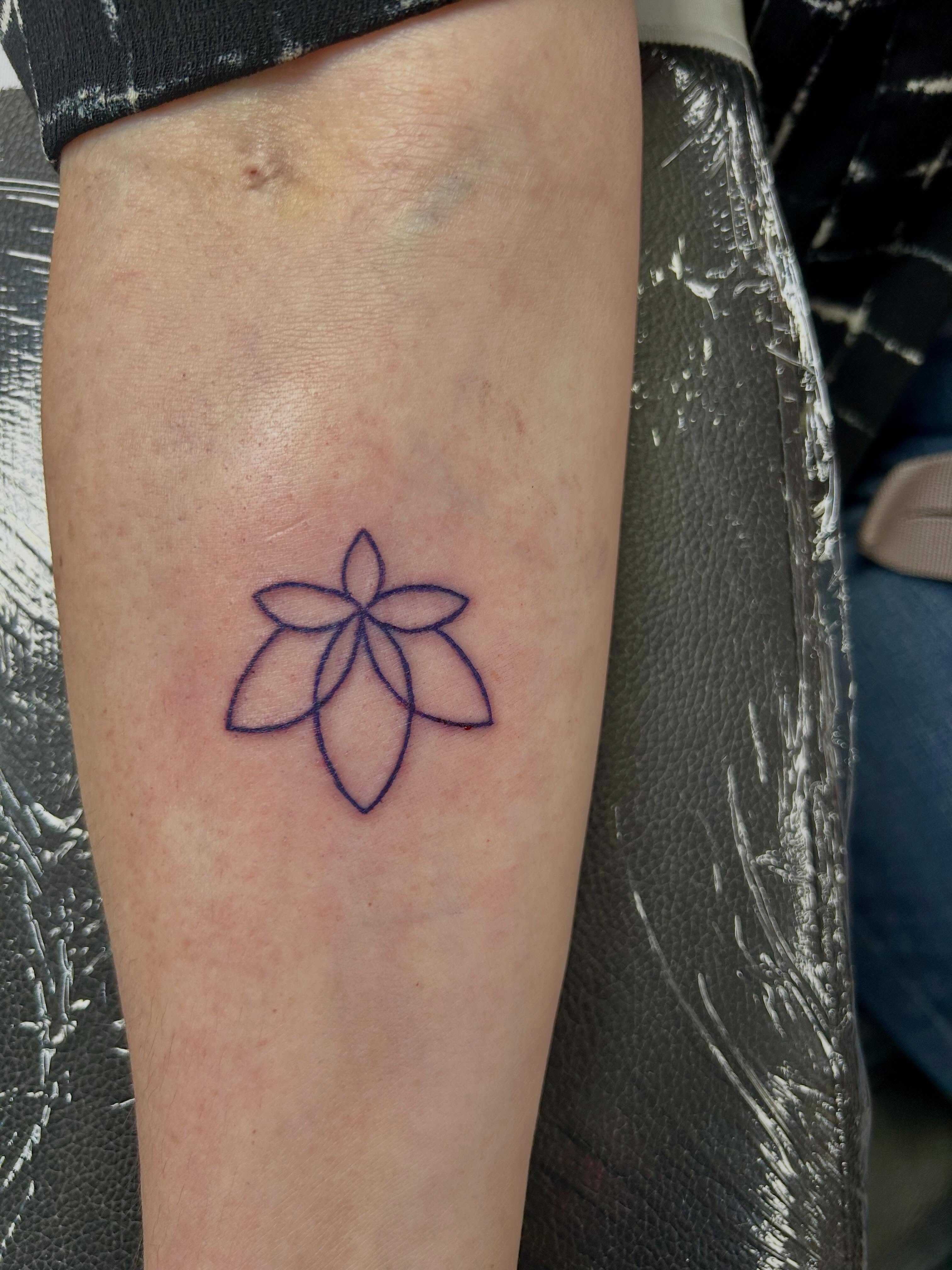 Lotus flower minimalist tattoo on the forearm by Bjorn Bjornstad, Dubuque, Iowa