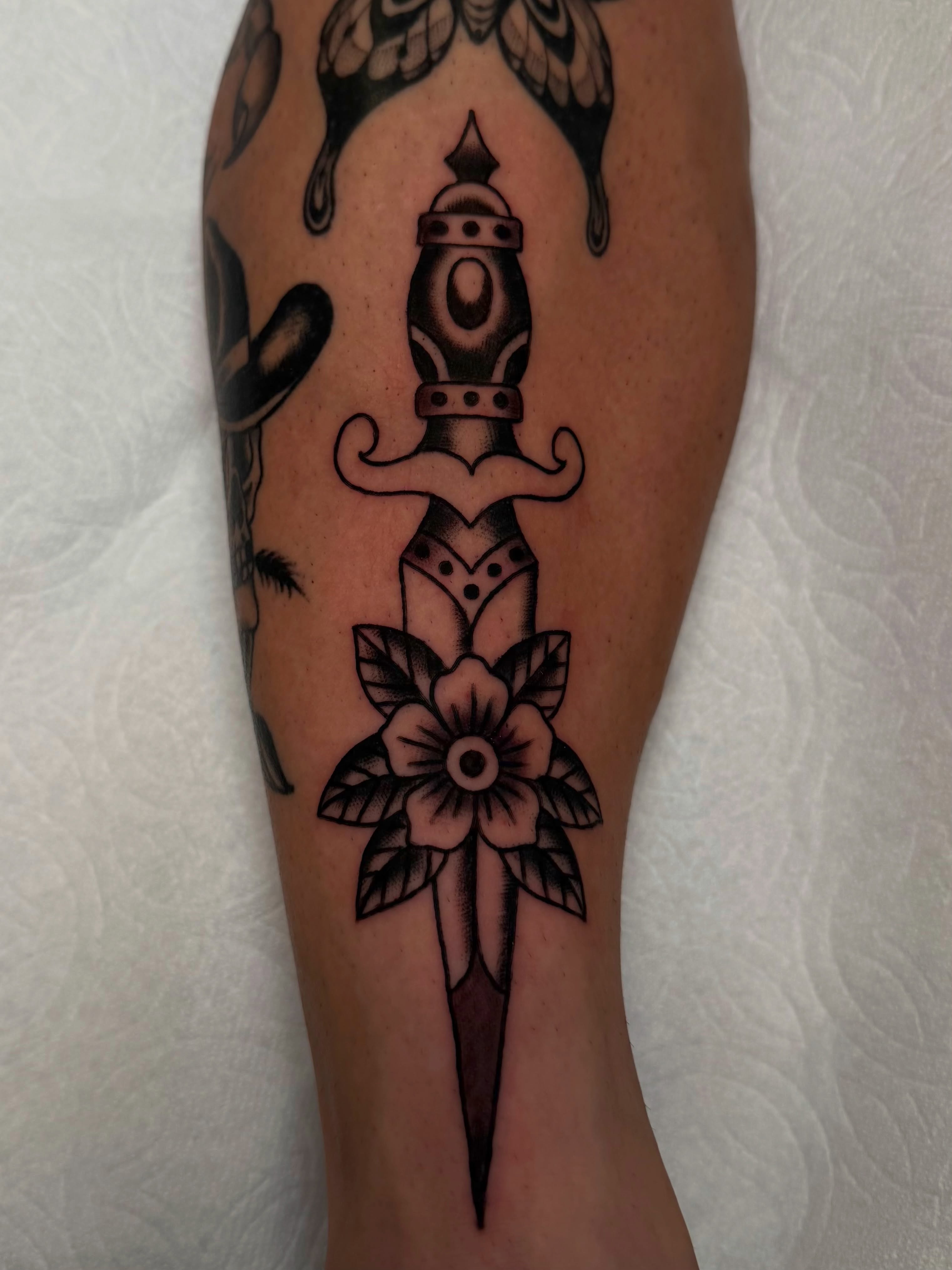 Knife and flower American traditional tattoo on the calf by Tyler Brown, San Diego, California