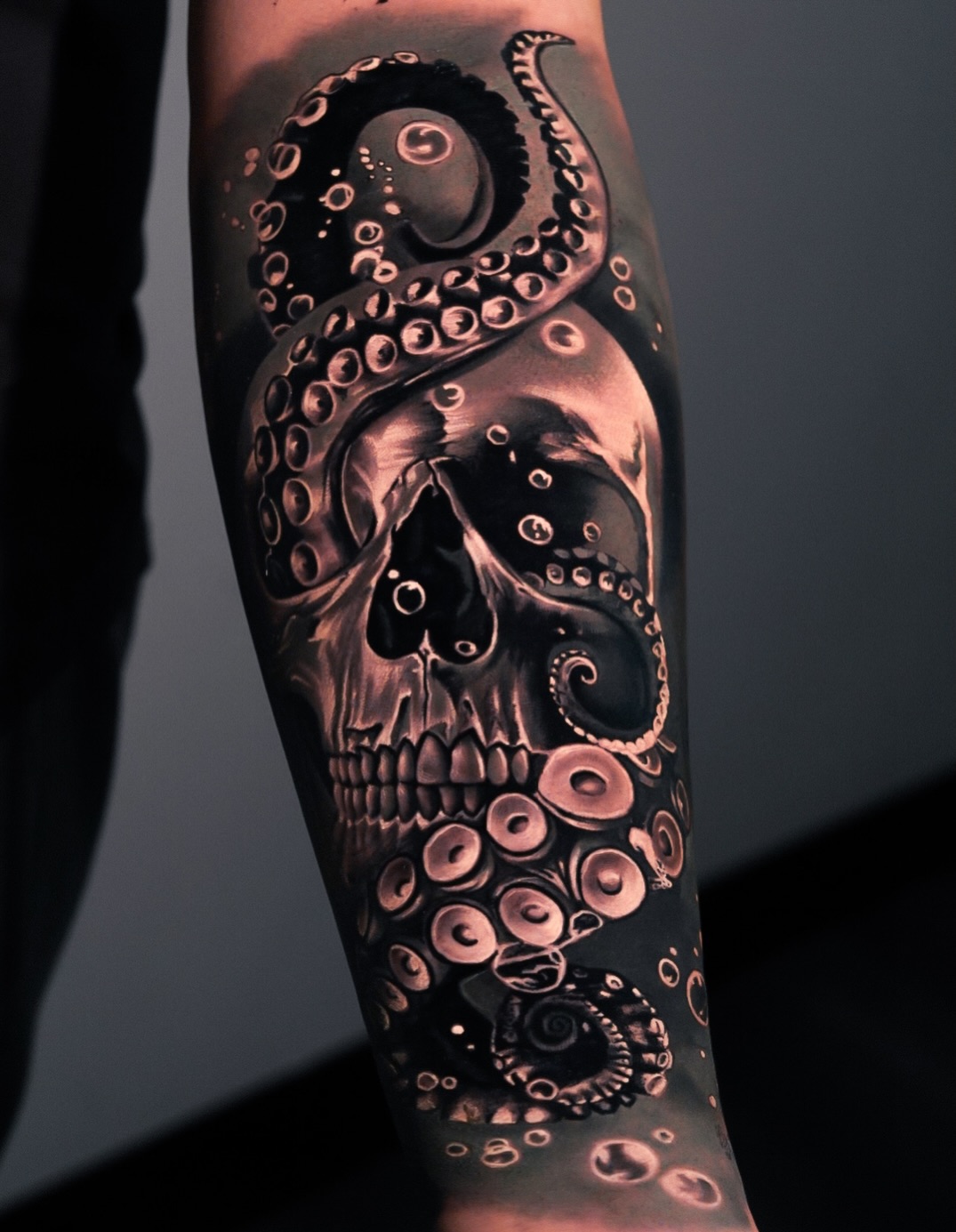 Skull and octopus tentacles dark art tattoo on the forearm by George Lange