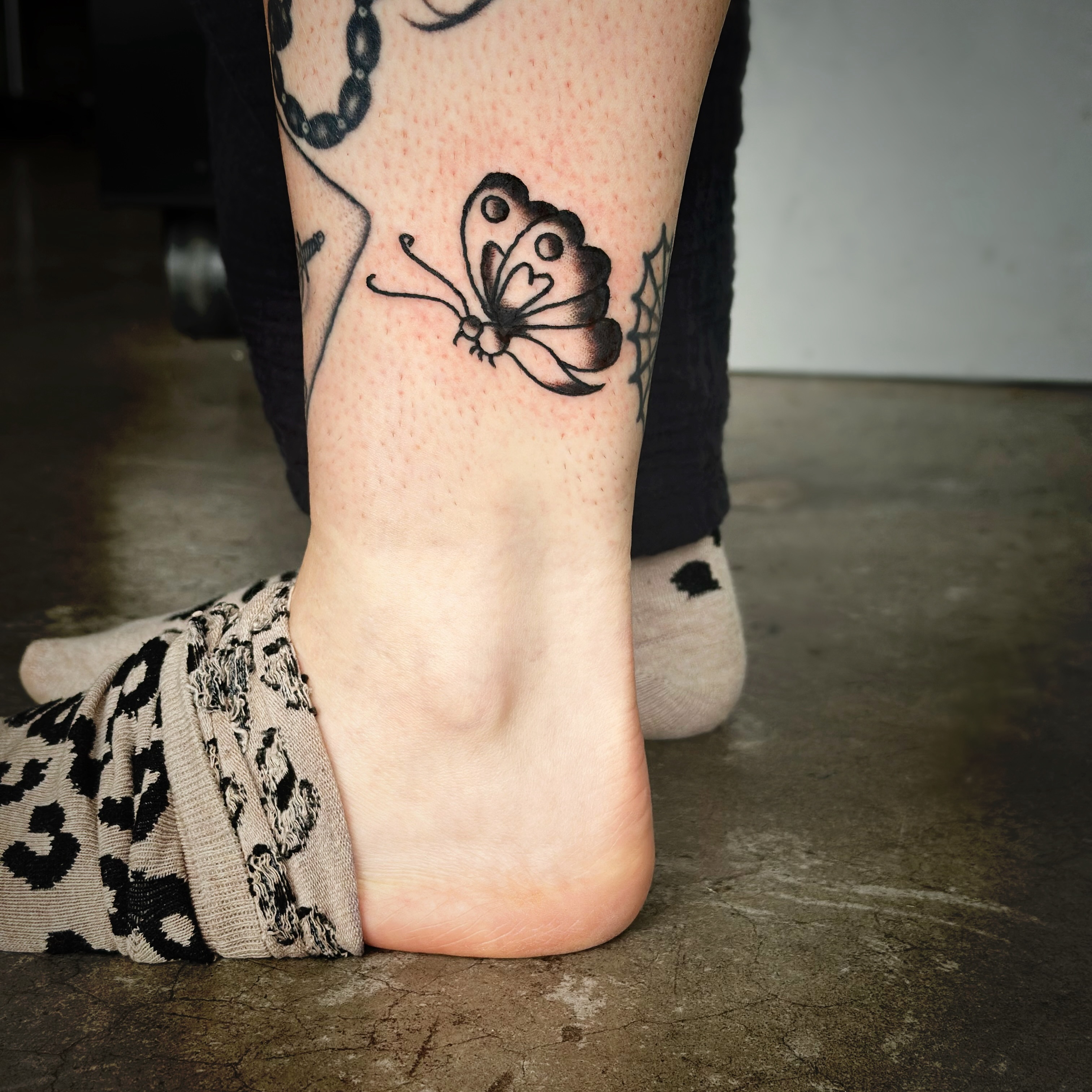 Butterfly black and grey tattoo on the foot by Madeline Seeley