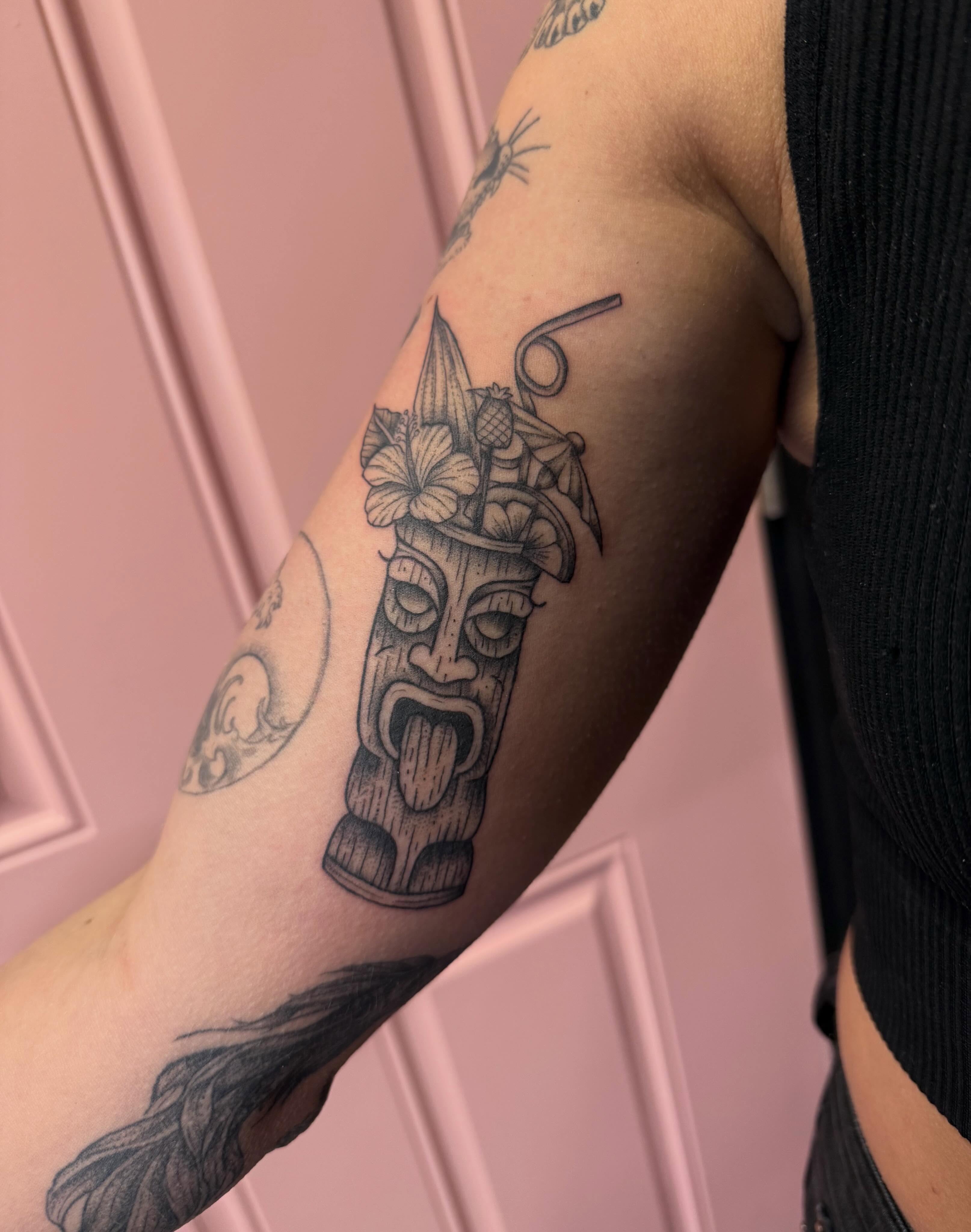 Tiki mask black and grey tattoo on the forearm by Jennylee Aerts, Asbury Park, New Jersey