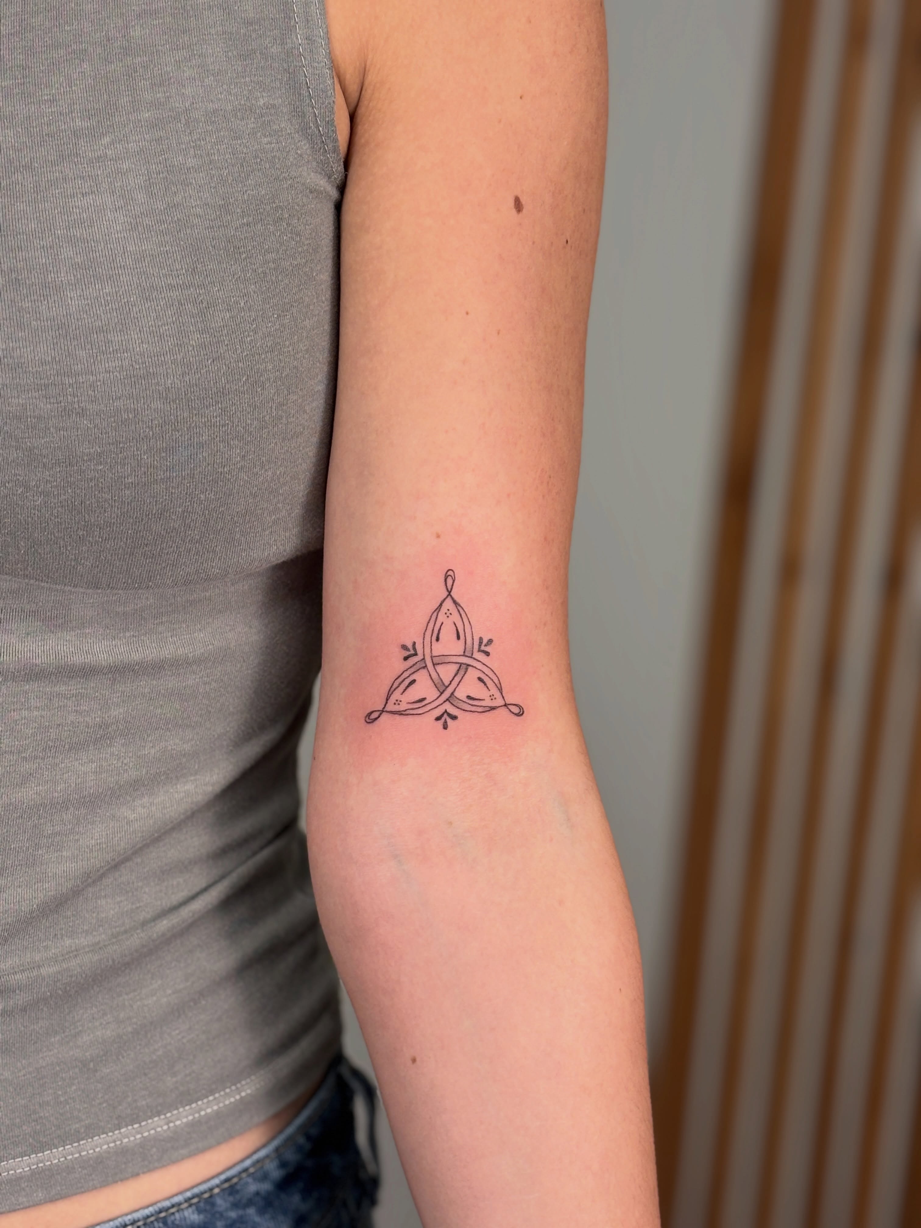 Trinity knot geometric tattoo on the forearm by Maddie