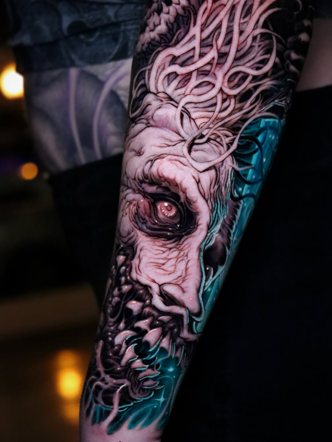Monstrous face with glowing elements dark art tattoo on the forearm by Jose Cruz Velazquez