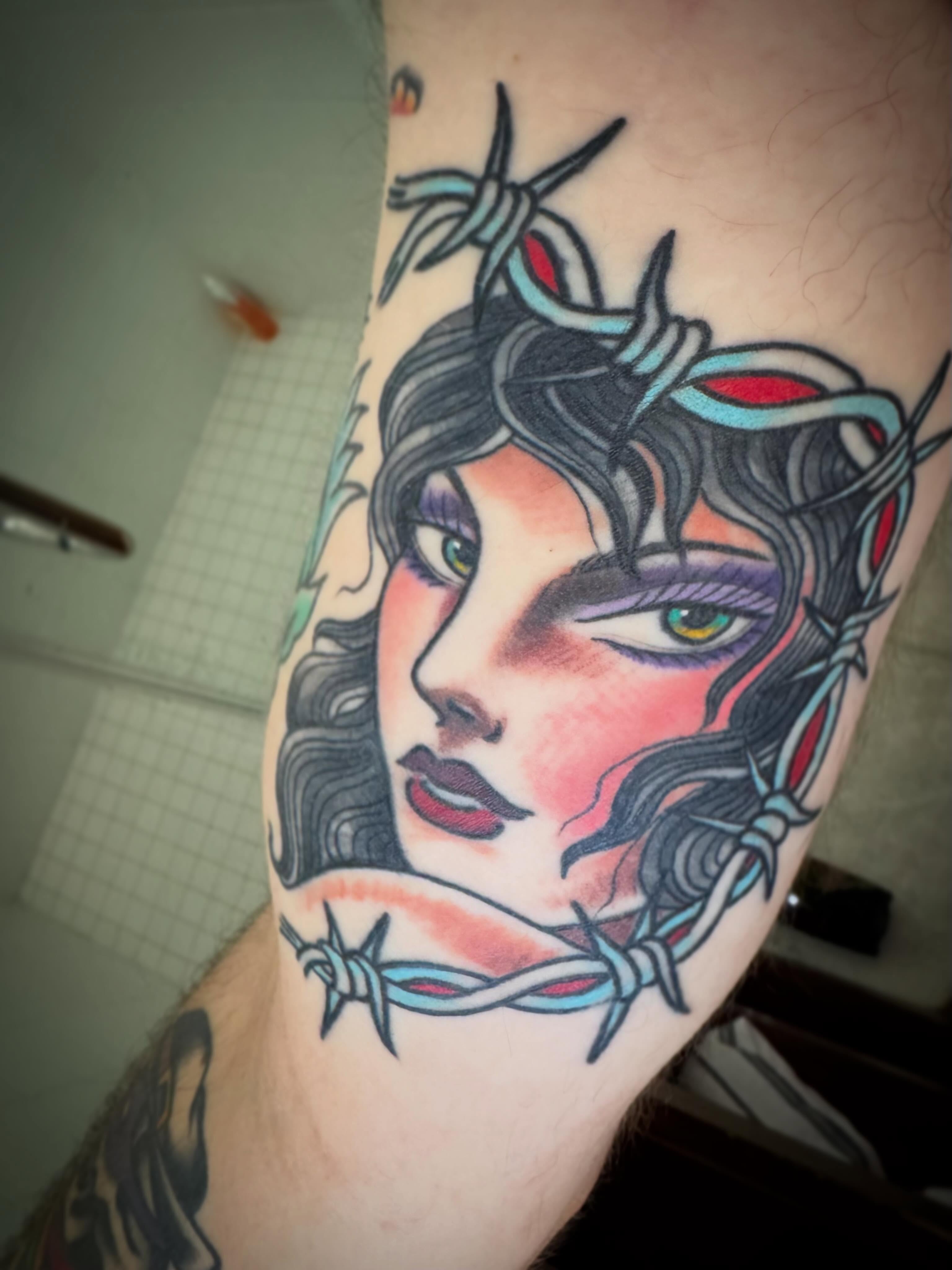 Woman with barbed wire crown American traditional tattoo on the forearm by Hayden Abernathy