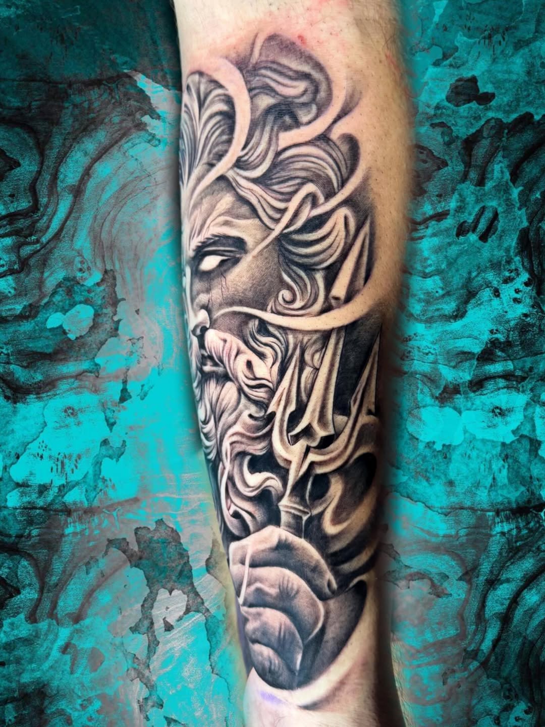 Poseidon with trident dark art tattoo on the forearm by Luis Chauta