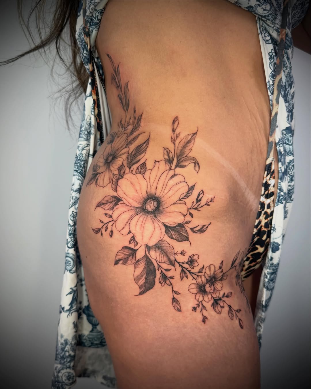Floral bouquet black and grey tattoo on the ribs by Felipe Pacifico