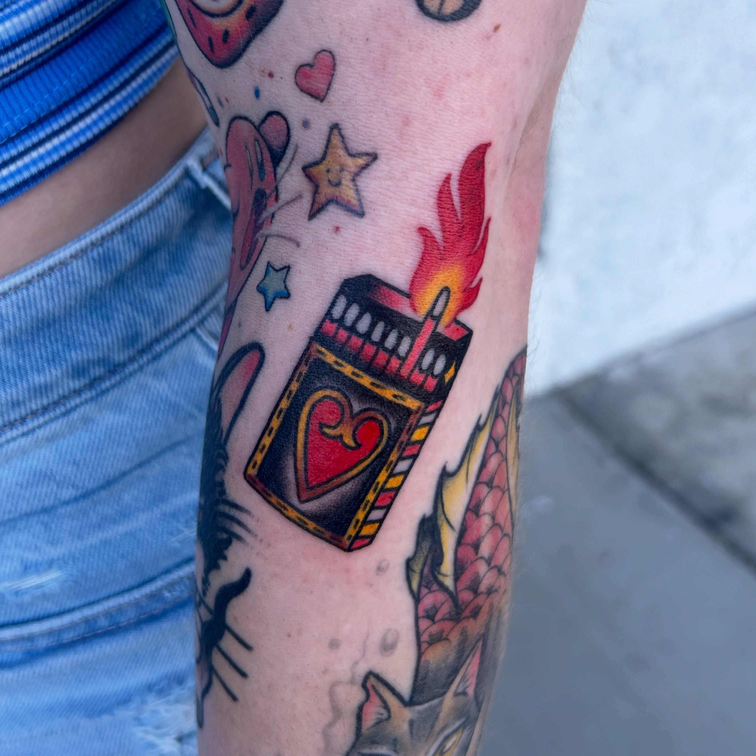 Burning heart card American traditional tattoo on the forearm by Vivian Nguyen