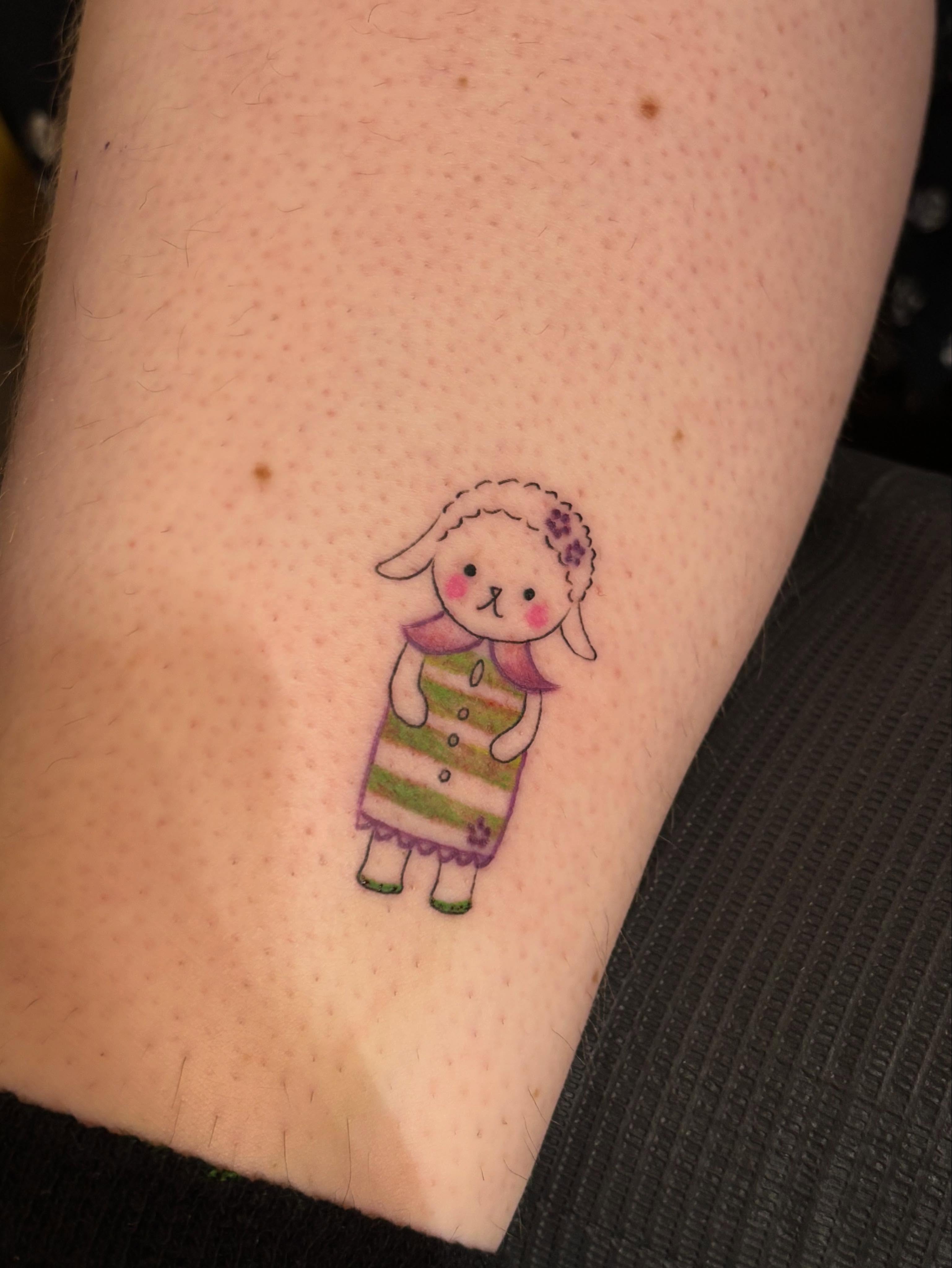 Sheep in dress illustrative tattoo on the forearm by Jennifer Flores