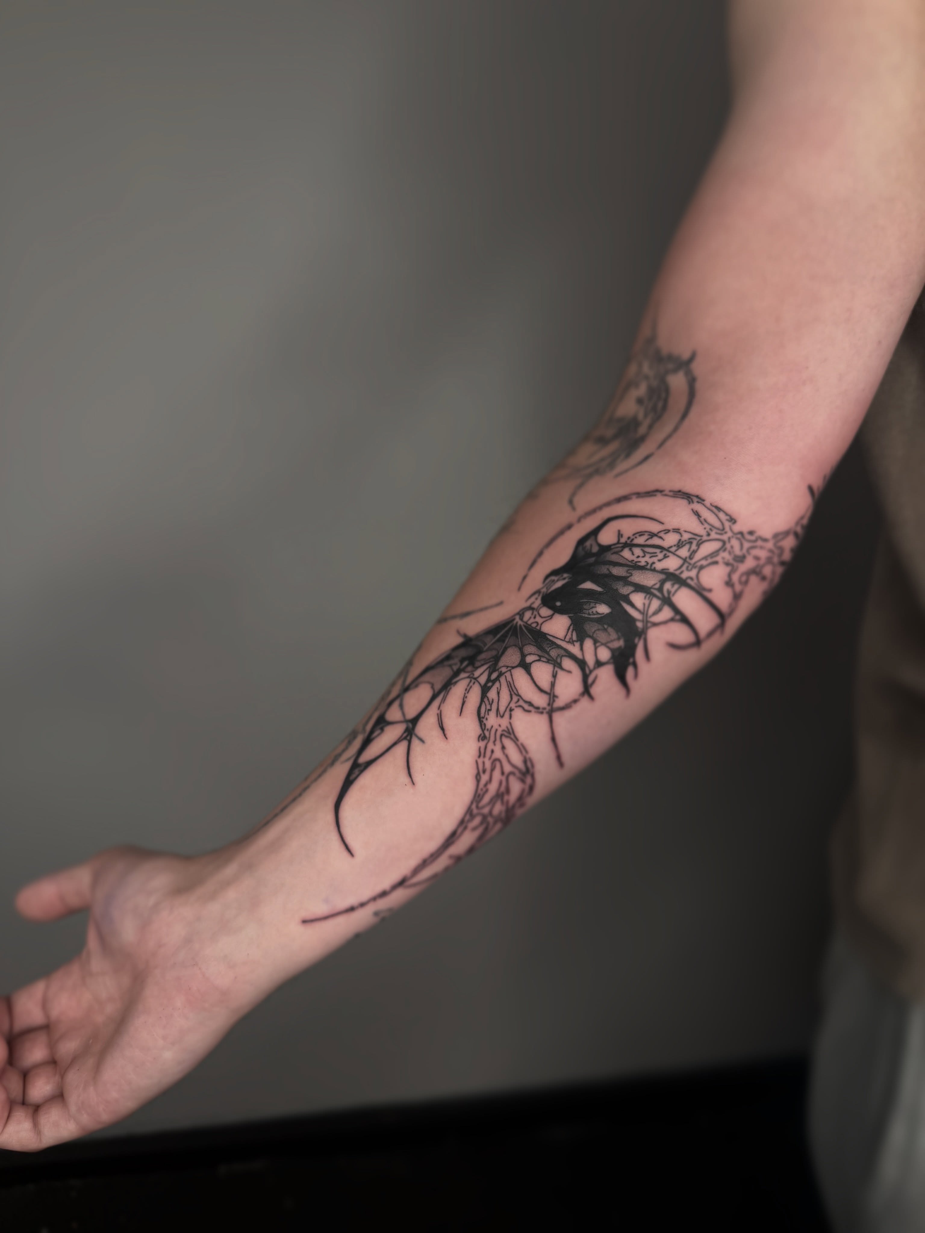 Abstract dragon tribal tattoo on the forearm by Brandon Shelby