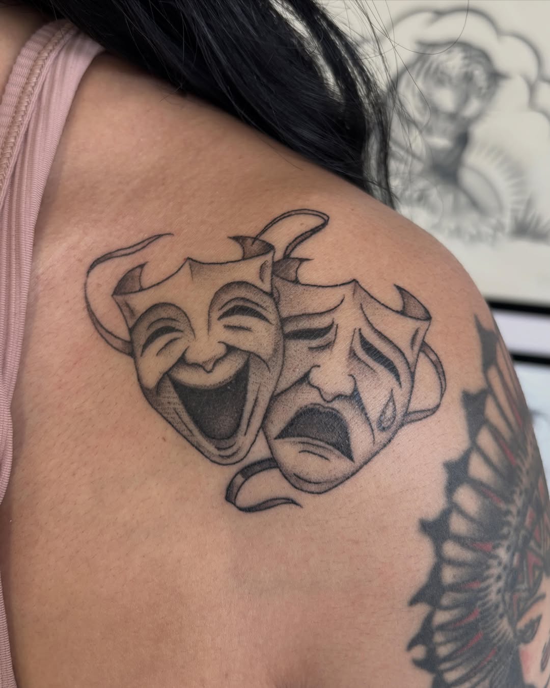 Theatrical masks black and grey tattoo on the shoulder by Amelia Rose, Los Angeles, California