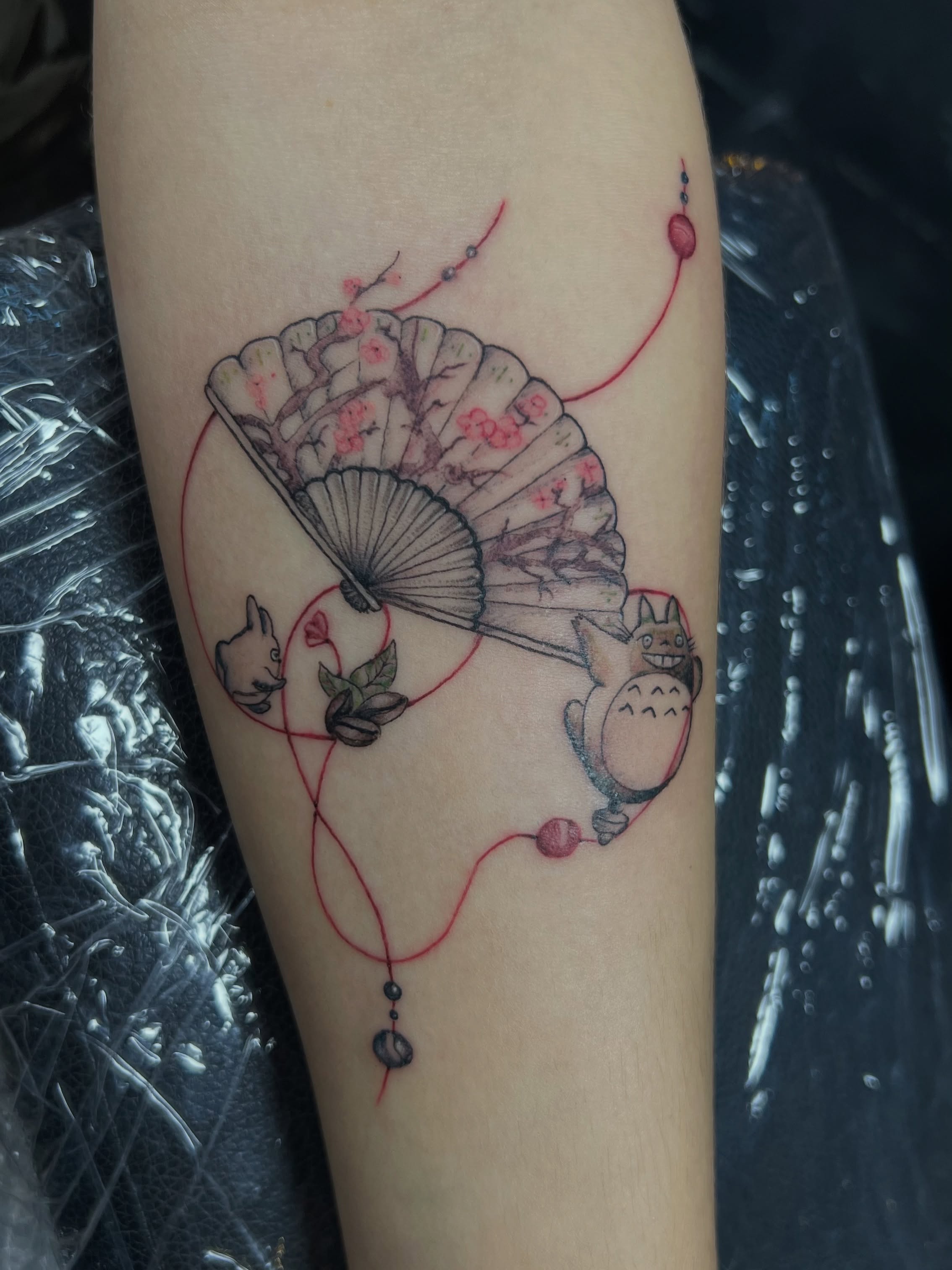 Totoro and fan dotwork tattoo on the forearm by Asap tattoo