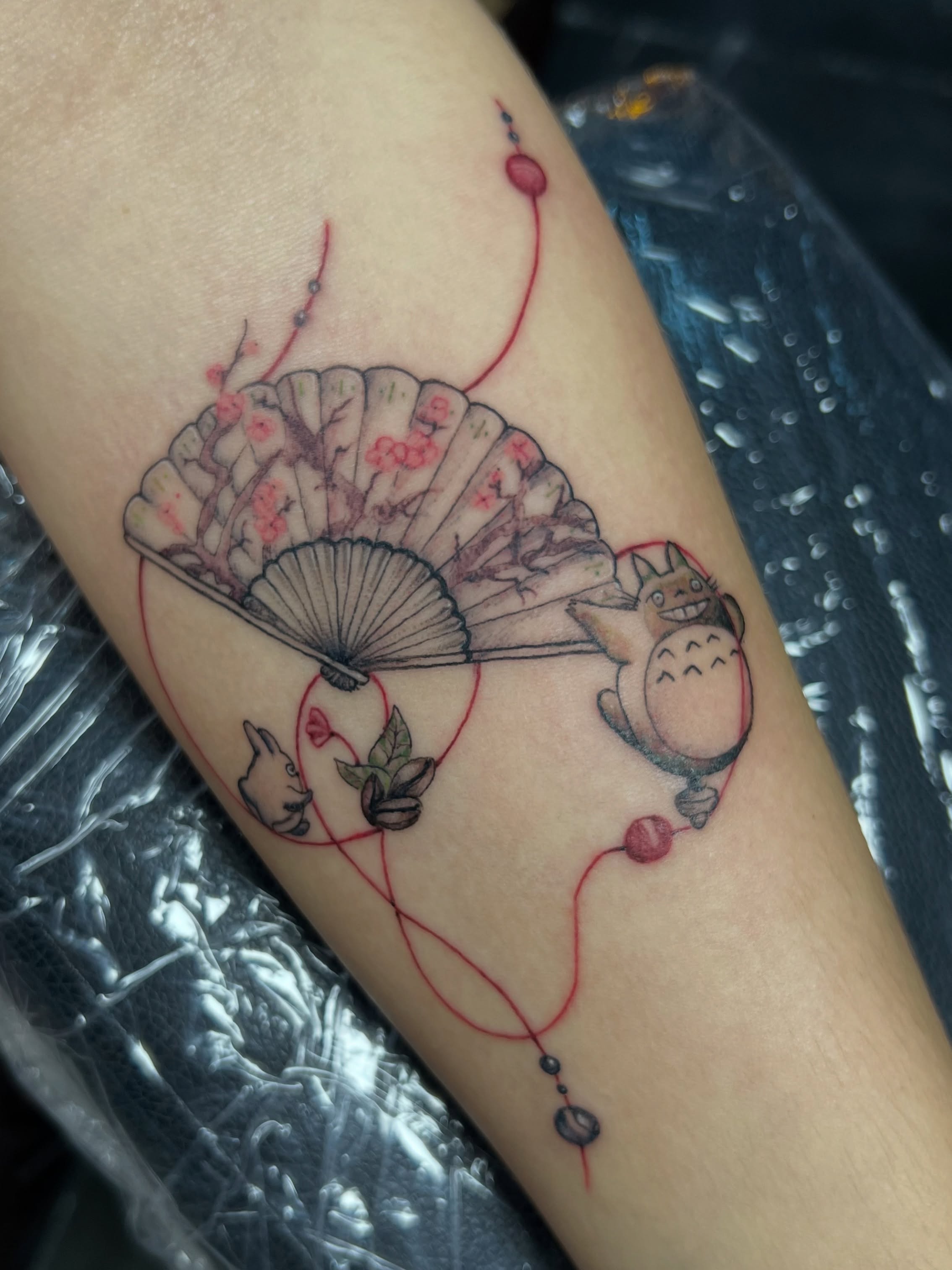 Totoro and fan dotwork tattoo on the forearm by Asap tattoo