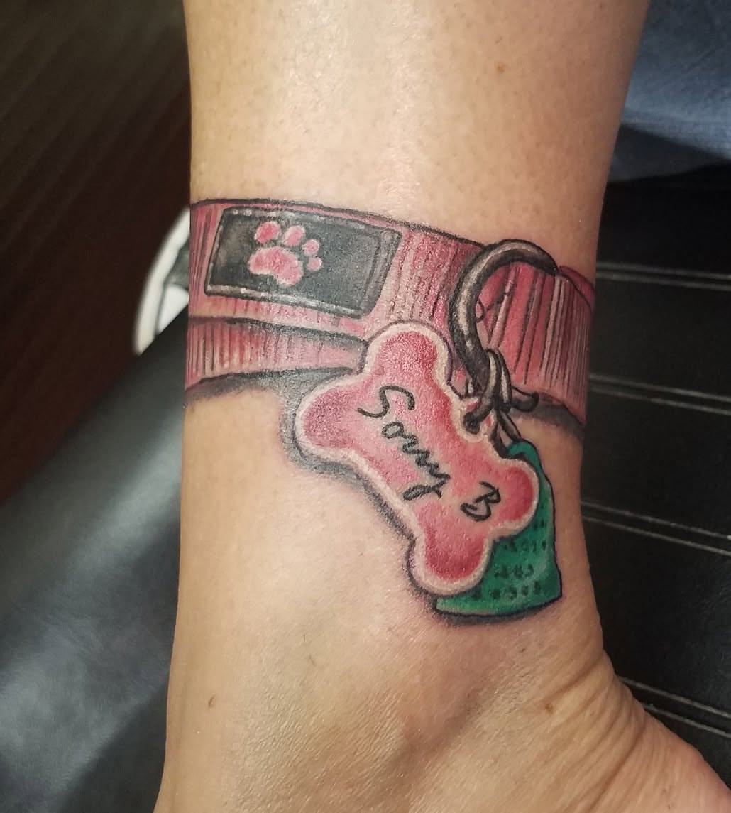 Dog collar and bone tag realism tattoo on the forearm by Oz Dillinger