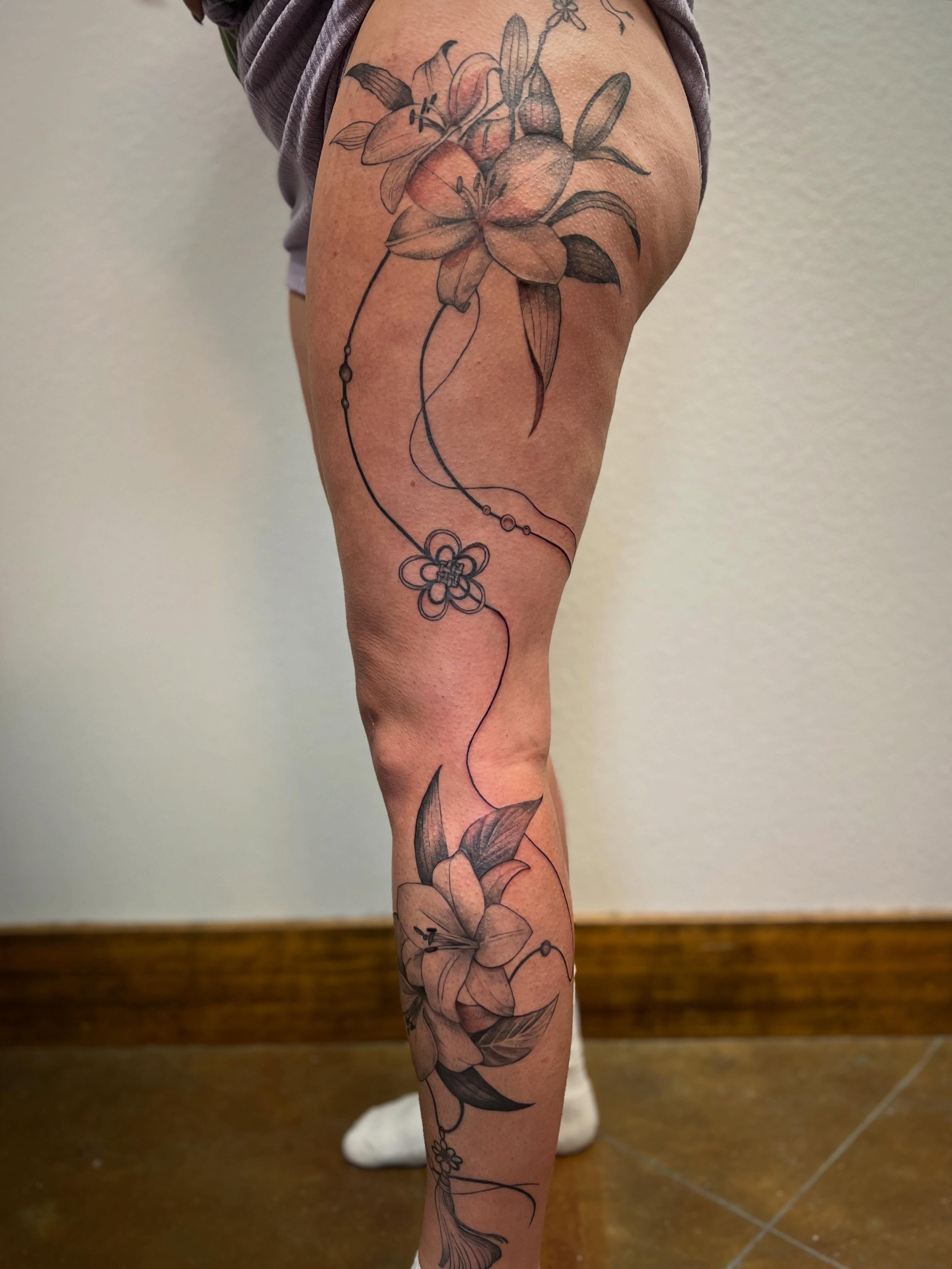 Lilies realism tattoo on the thigh by Rebecca Kern Tattoos