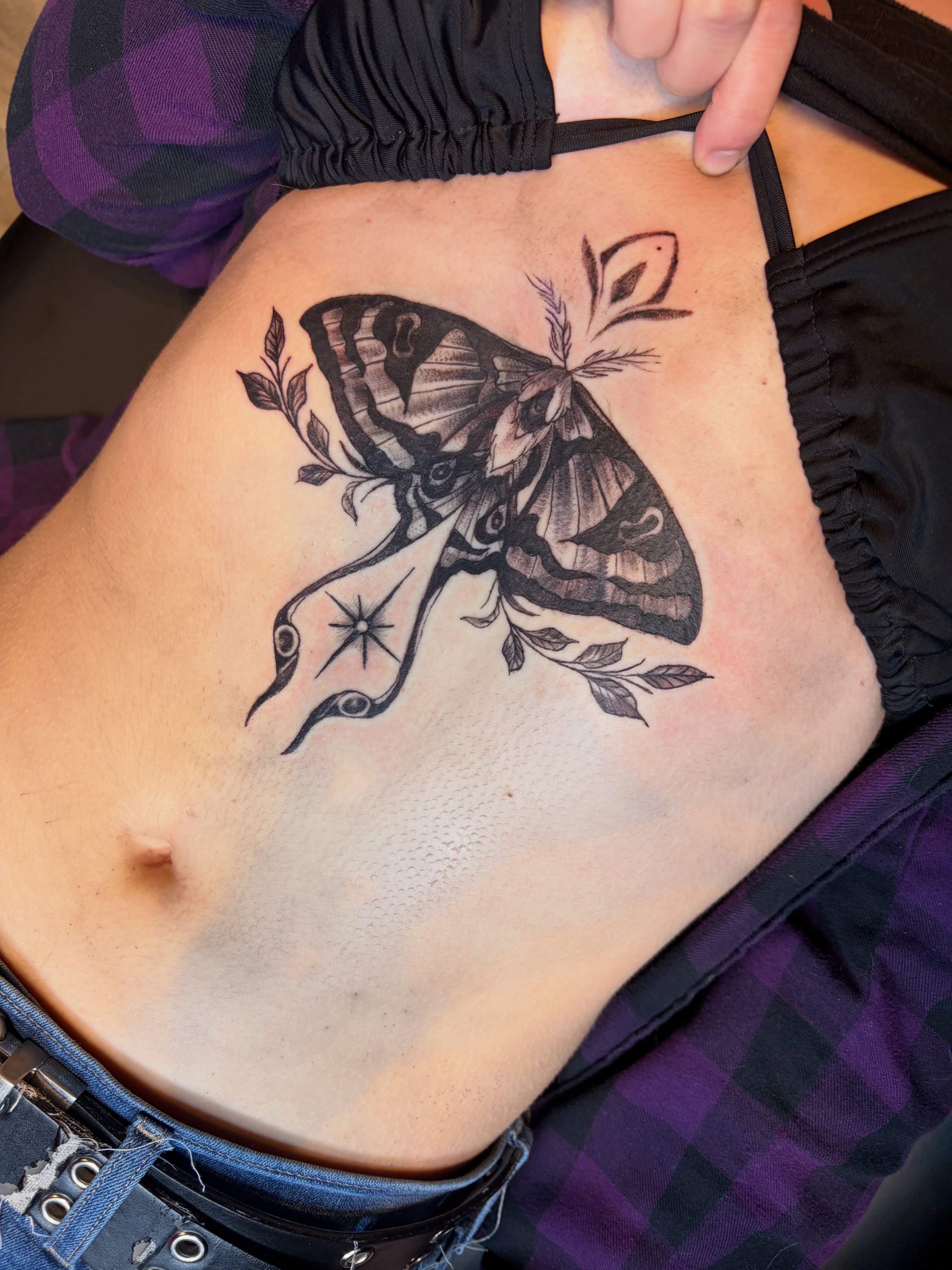 Moth and floral black and grey tattoo on the torso by Calen Copeland