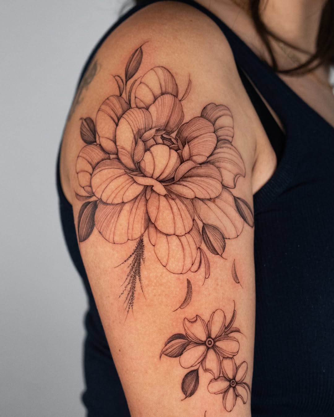 Peony black and grey tattoo on the upper arm by Tattoo fine line NY