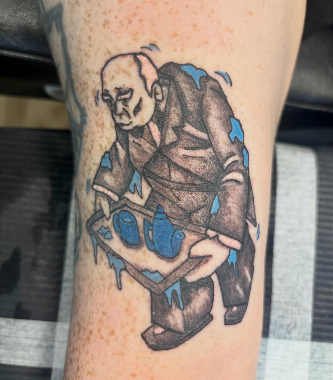 Elderly man carrying tray black and grey tattoo on the forearm by Natalie Jade Shupe