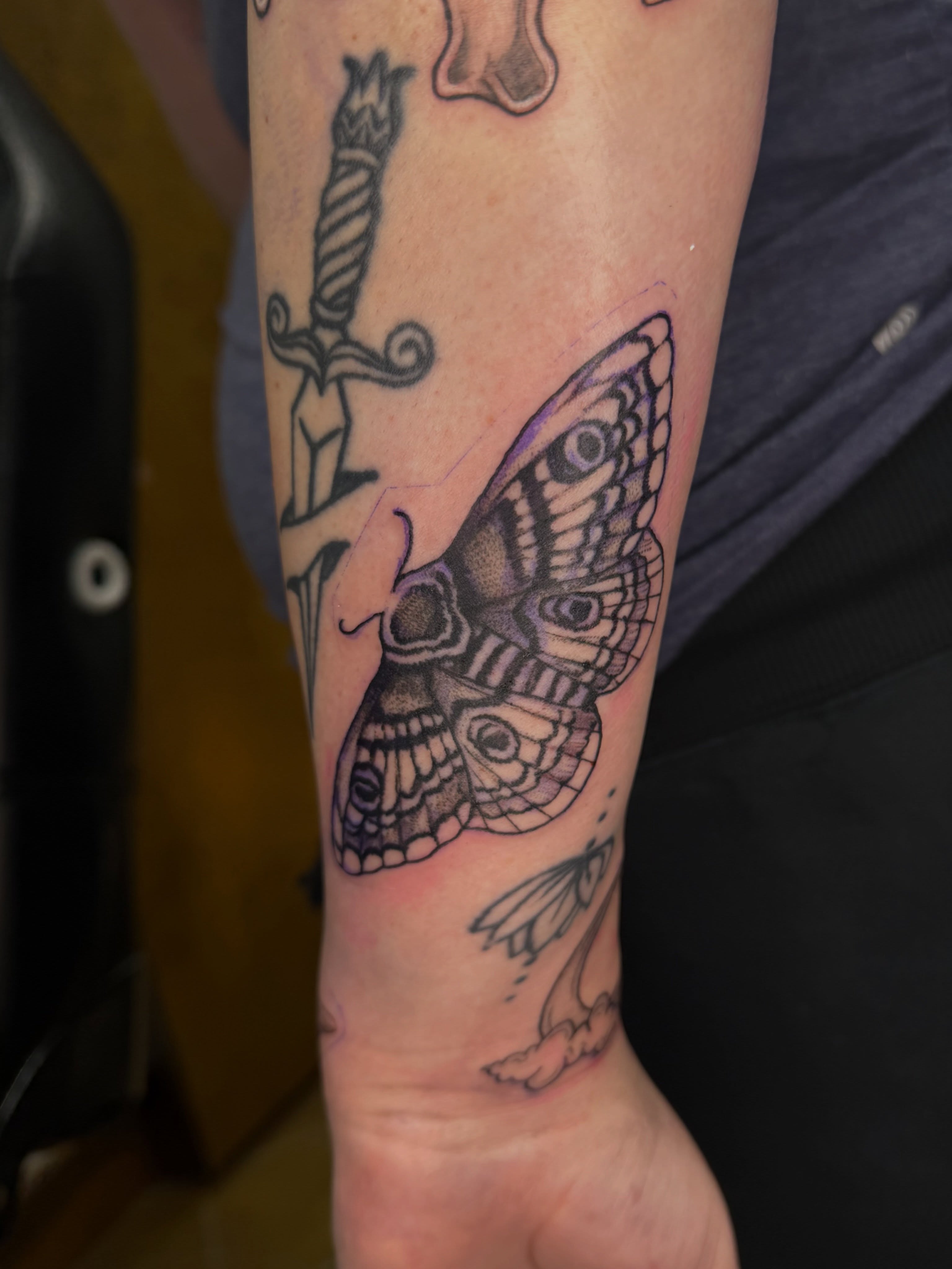 Moth black and grey tattoo on the forearm by Halle Cooper