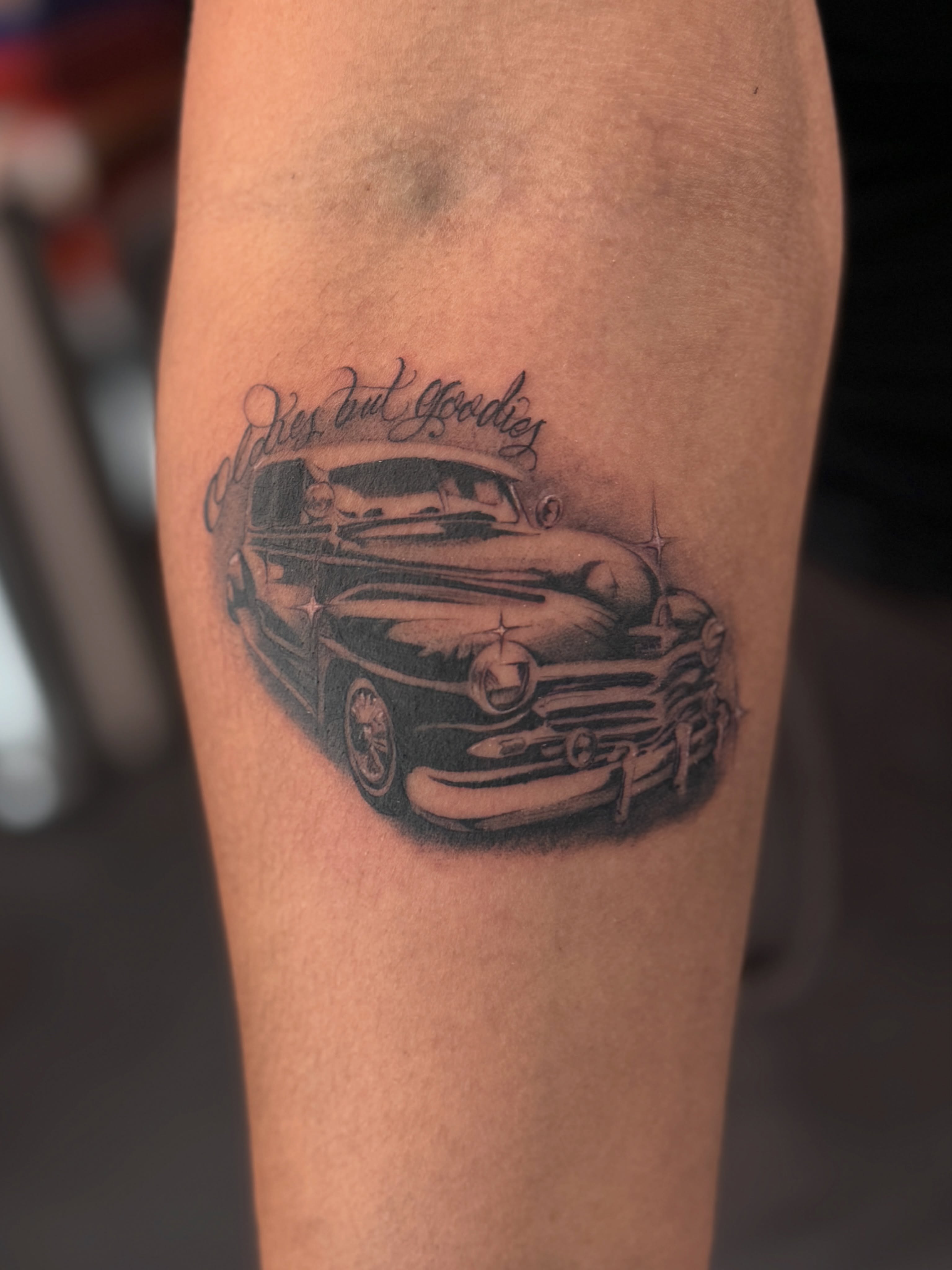 Classic car black and grey tattoo on the forearm by tombstone