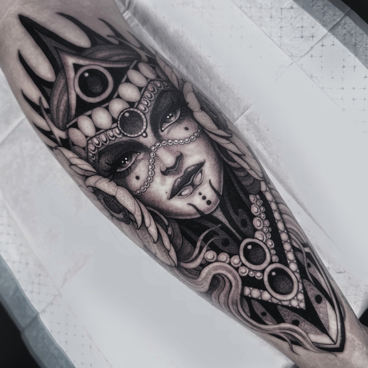 Woman with intricate headdress realism tattoo on the forearm by Tommy Sisneros