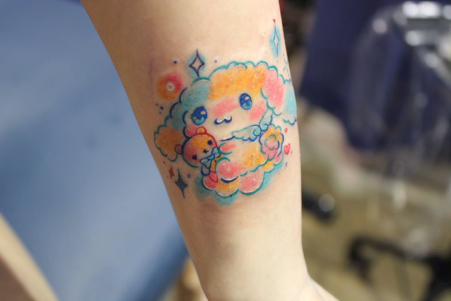 Cloud character watercolor tattoo on the forearm by Sonder
