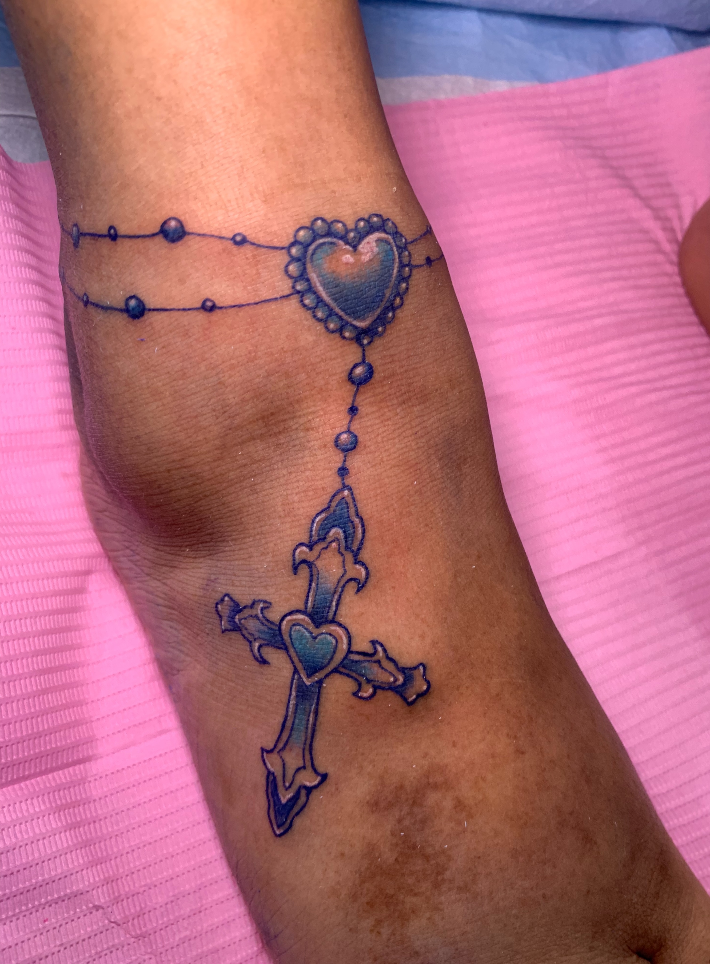 Cross with heart ornamental tattoo on the forearm by Aubrianna Grisez