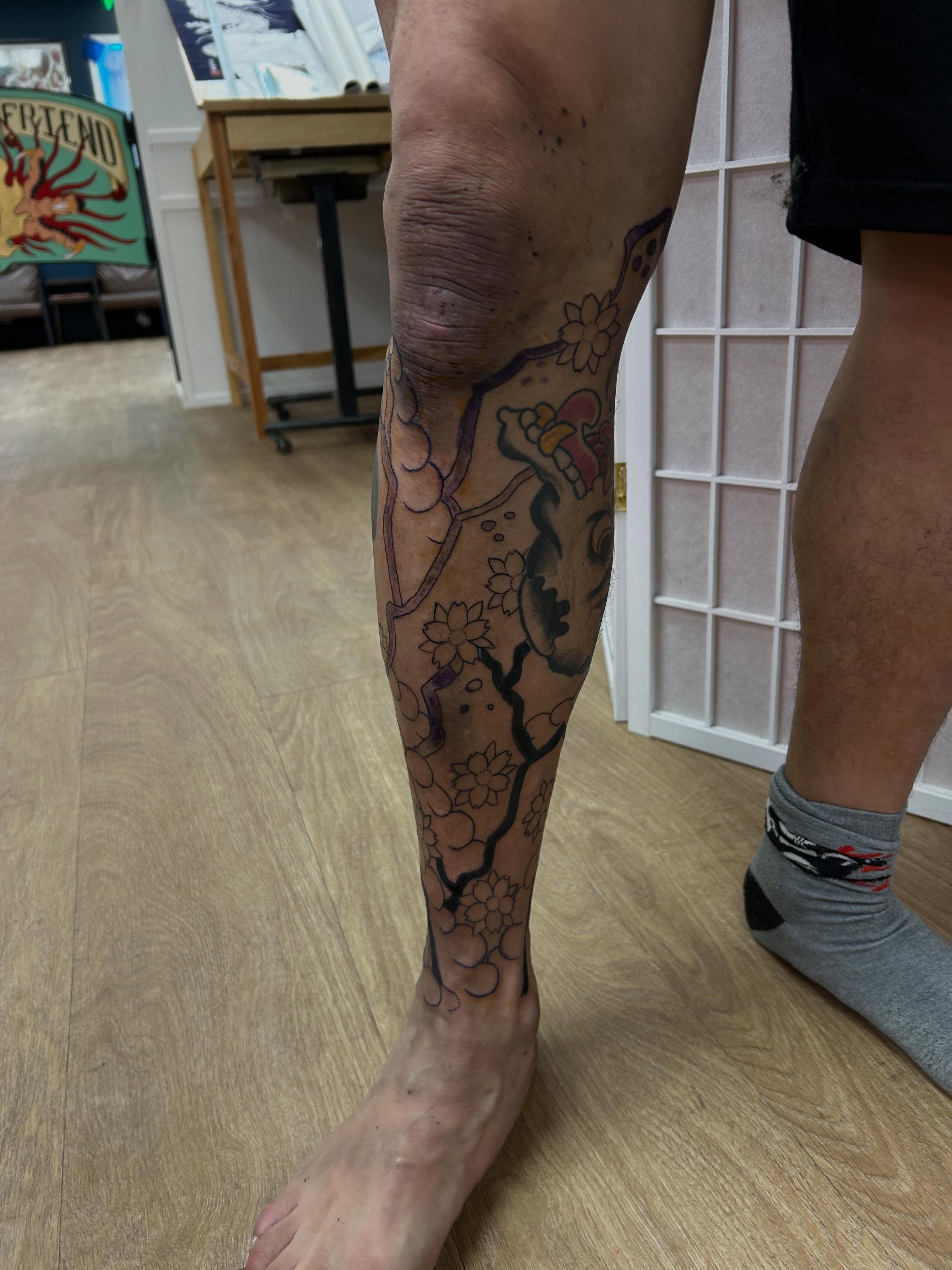 Cherry blossom tree black and grey tattoo on the calf by Stogie Tony