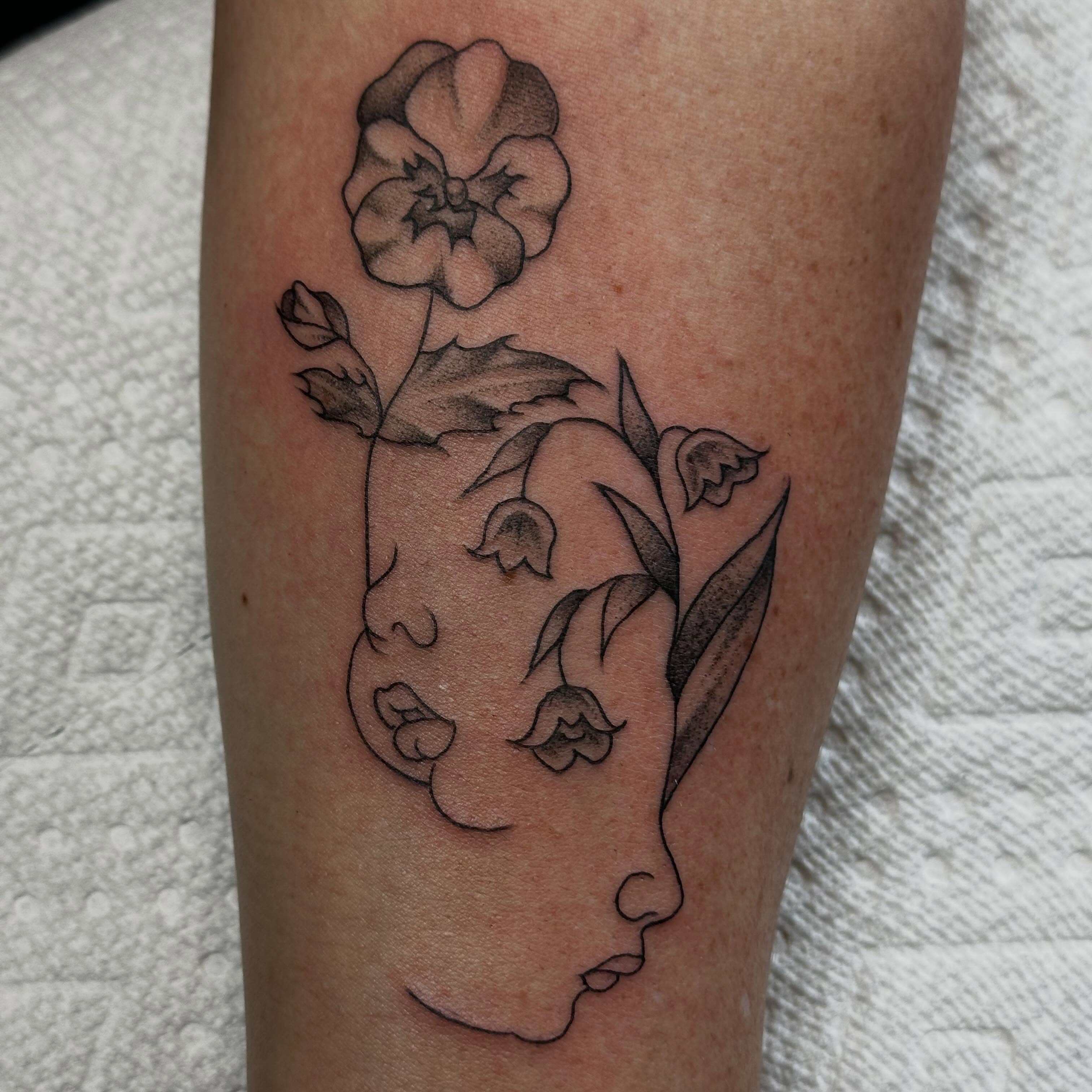 Floral profile black and grey tattoo on the forearm by Elisha B🦷