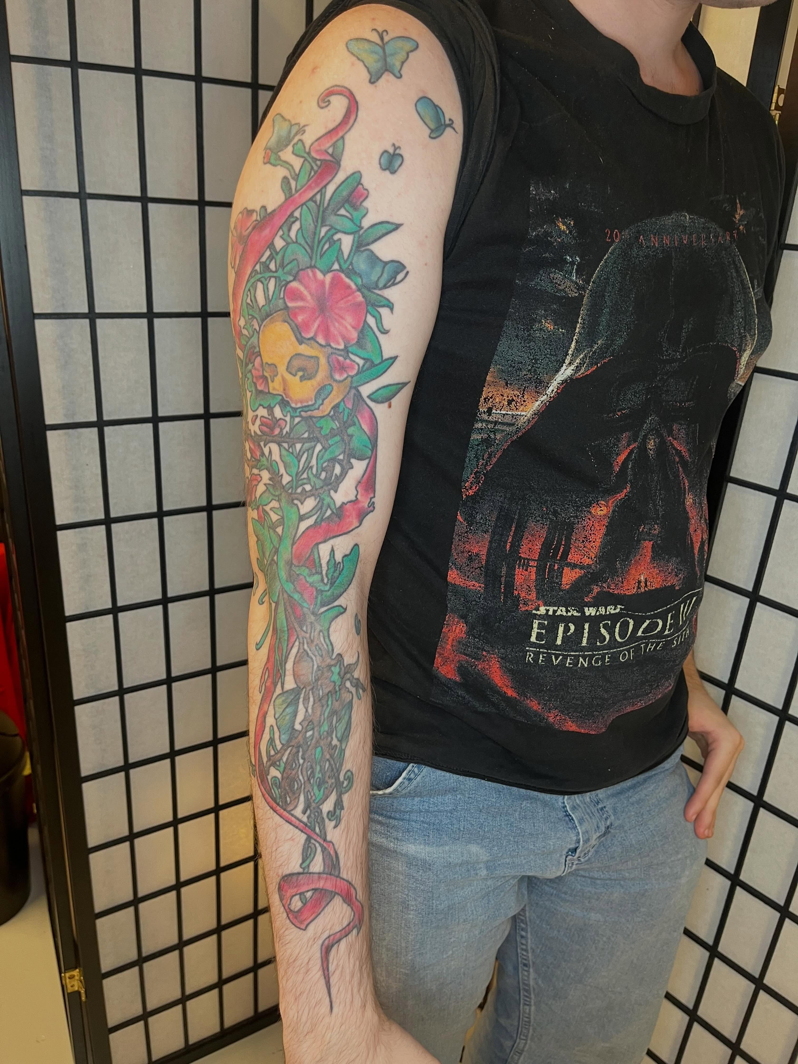 Skull and floral American traditional tattoo on the forearm by Lauryn Dunkle