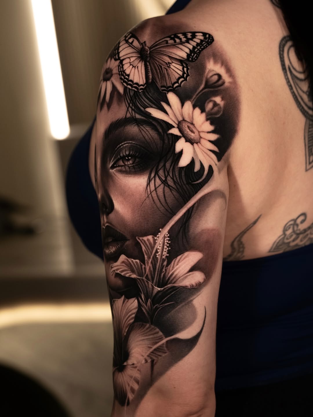 Woman's face with flowers and butterfly realism tattoo on the shoulder by @_garart_