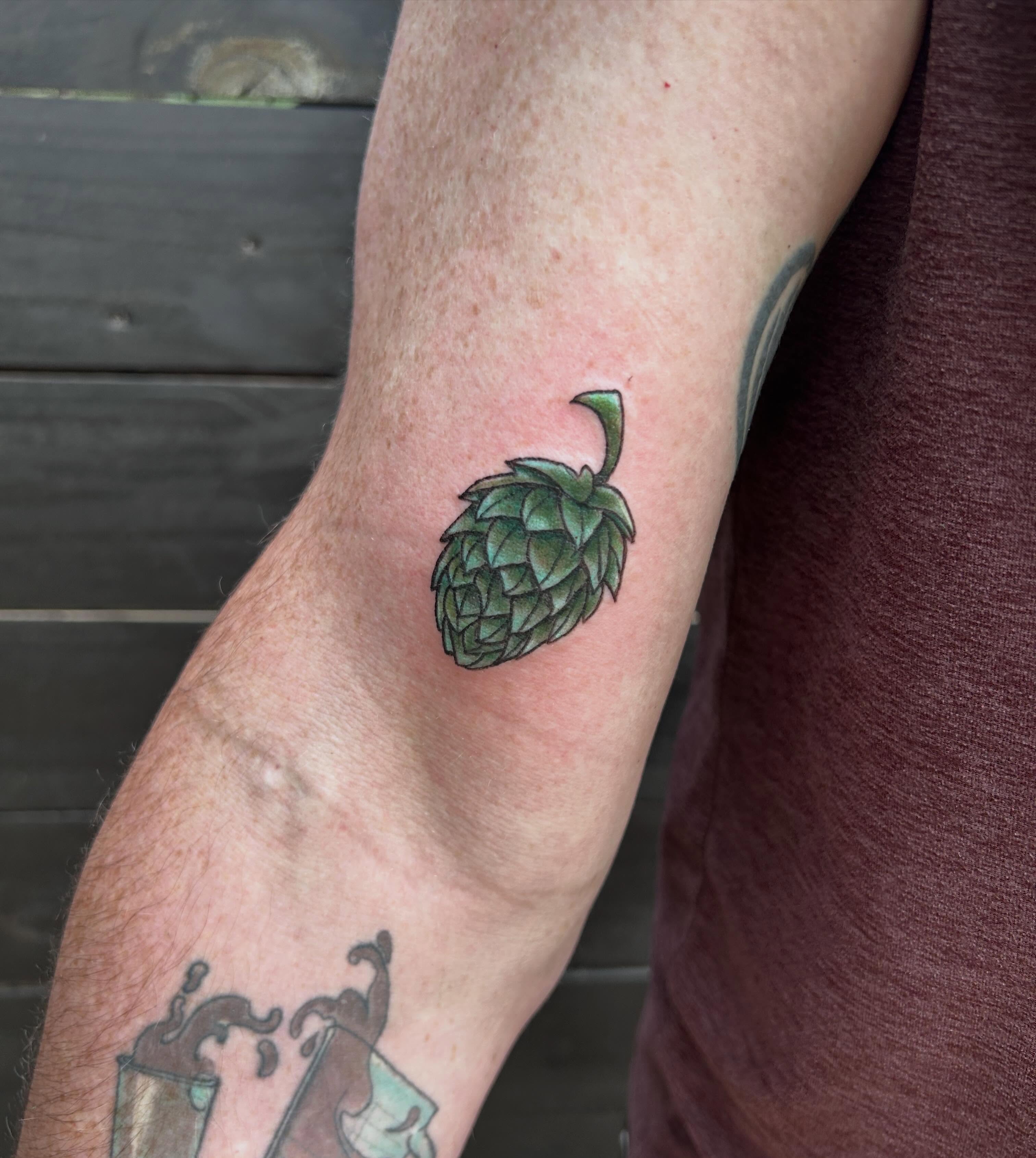 Hop cone realism tattoo on the forearm by Miss Katie