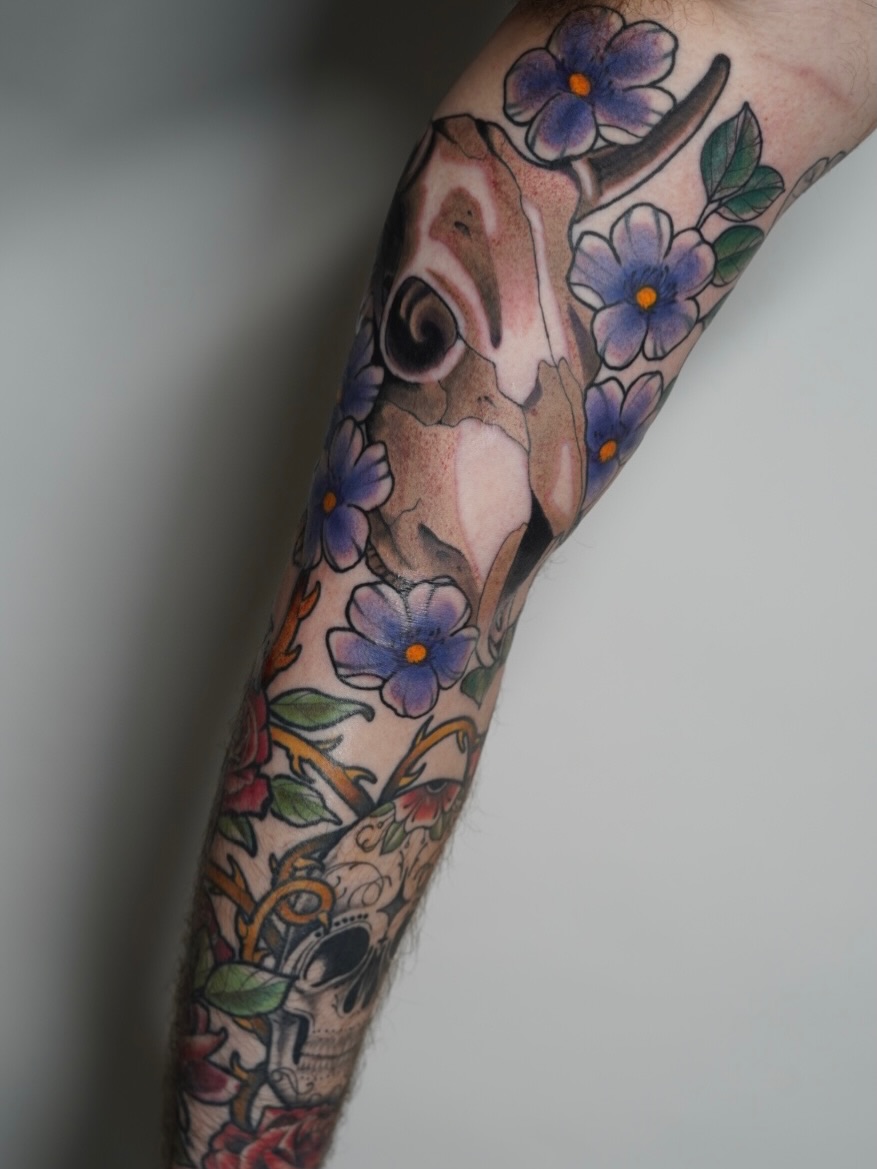 Deer and flowers American traditional tattoo on the forearm by autumn sky
