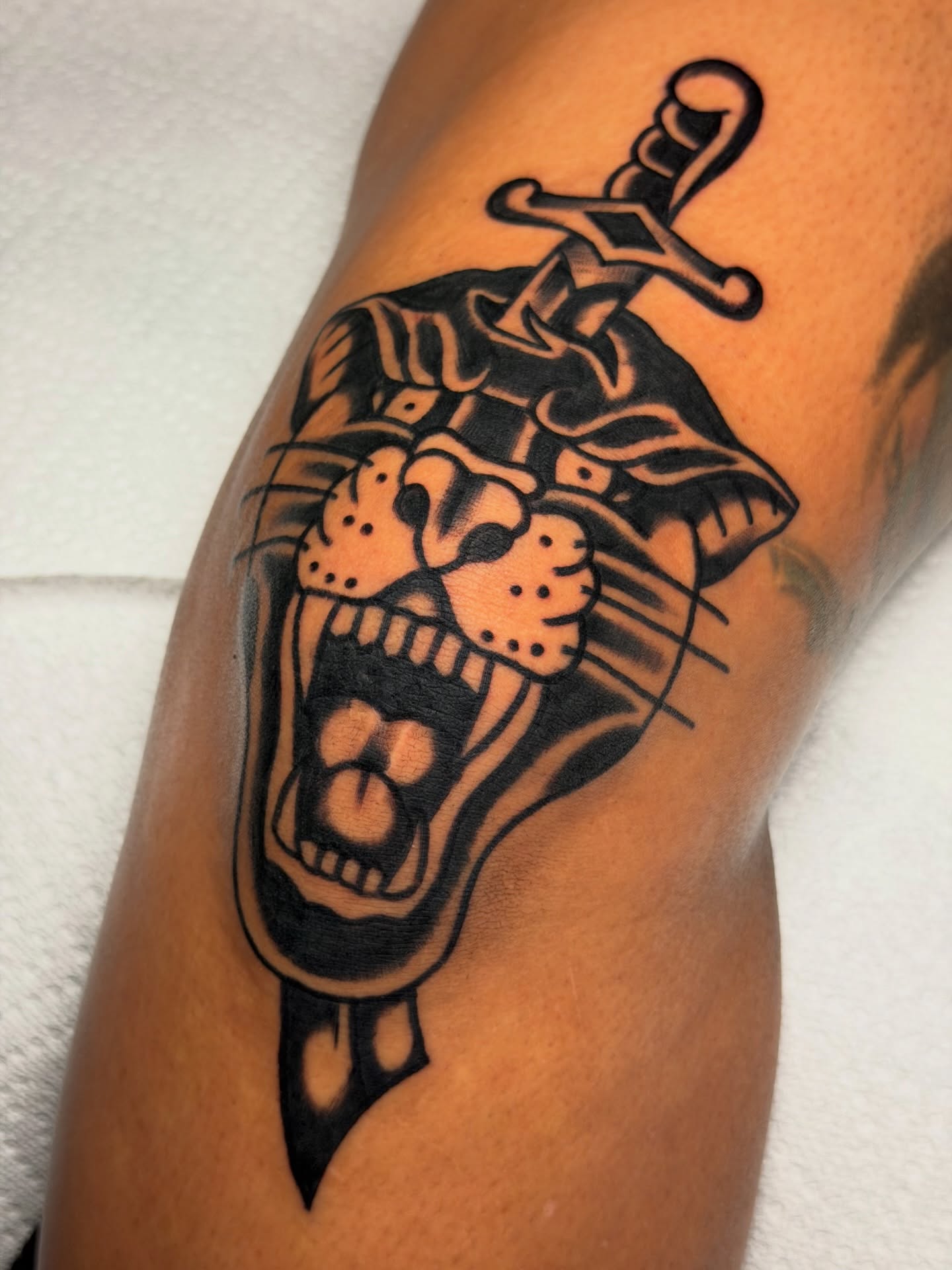 Skull with sword black and grey tattoo on the forearm by Kyle Dean Traditional Tattoo Artist