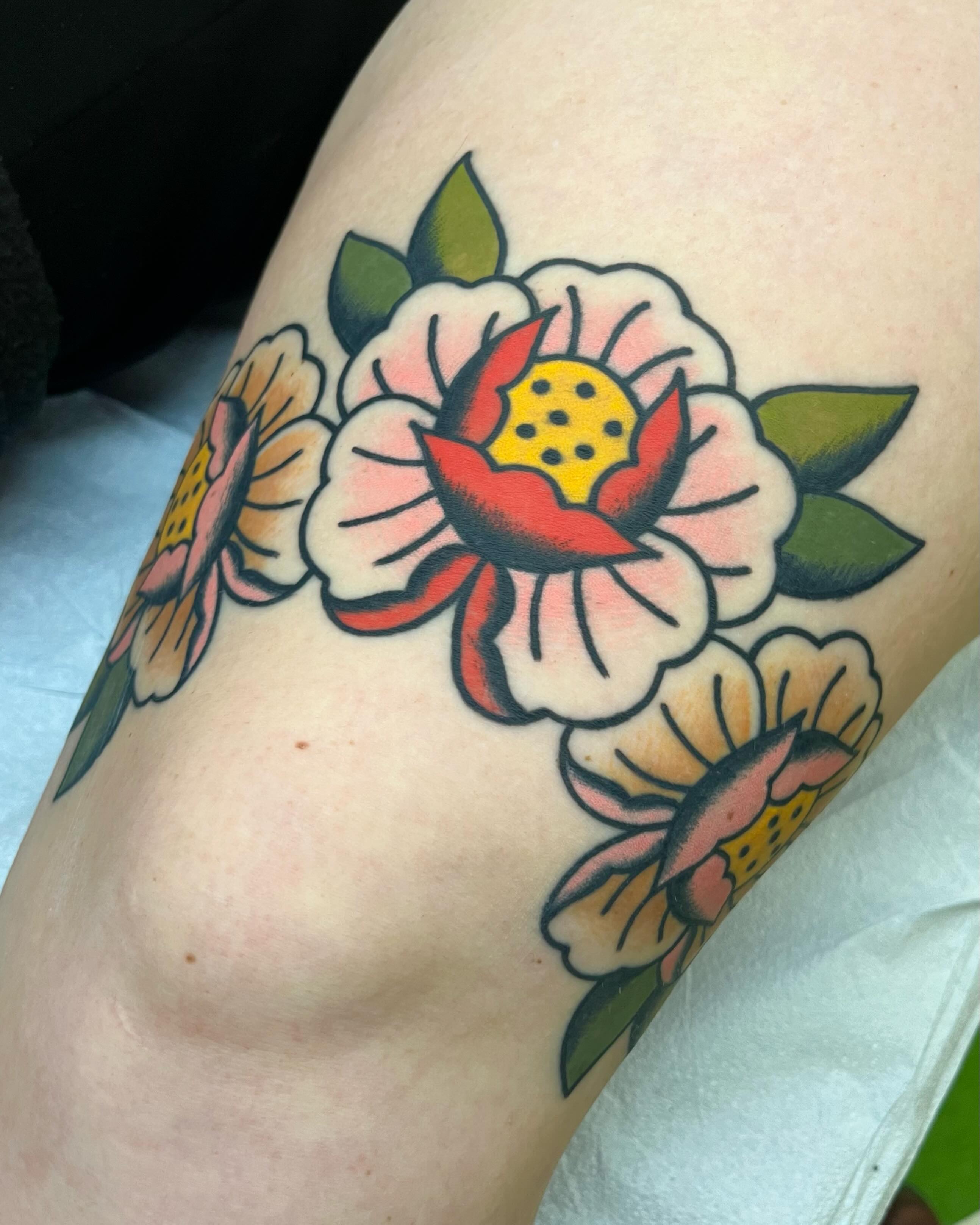 Floral arrangement American traditional tattoo on the thigh by Em Adkins