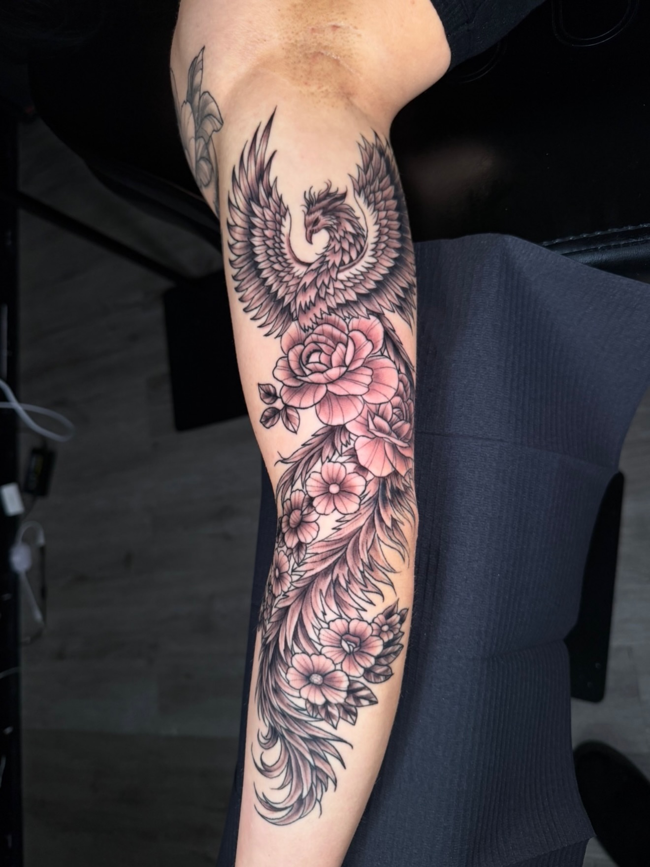 Phoenix and flowers black and grey tattoo on the forearm by Beau Zeis