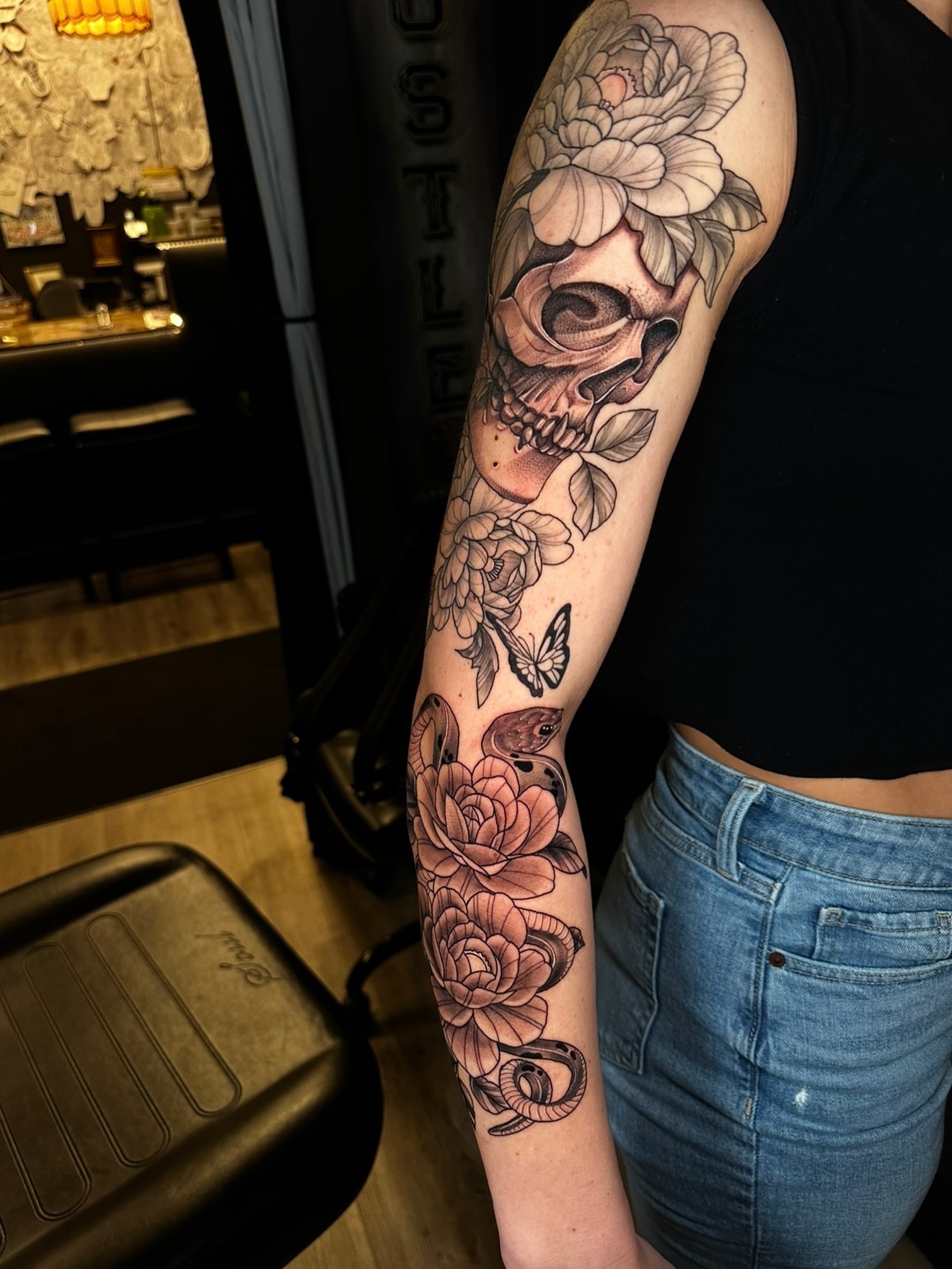 Floral skull realism tattoo on the forearm by Beau Zeis