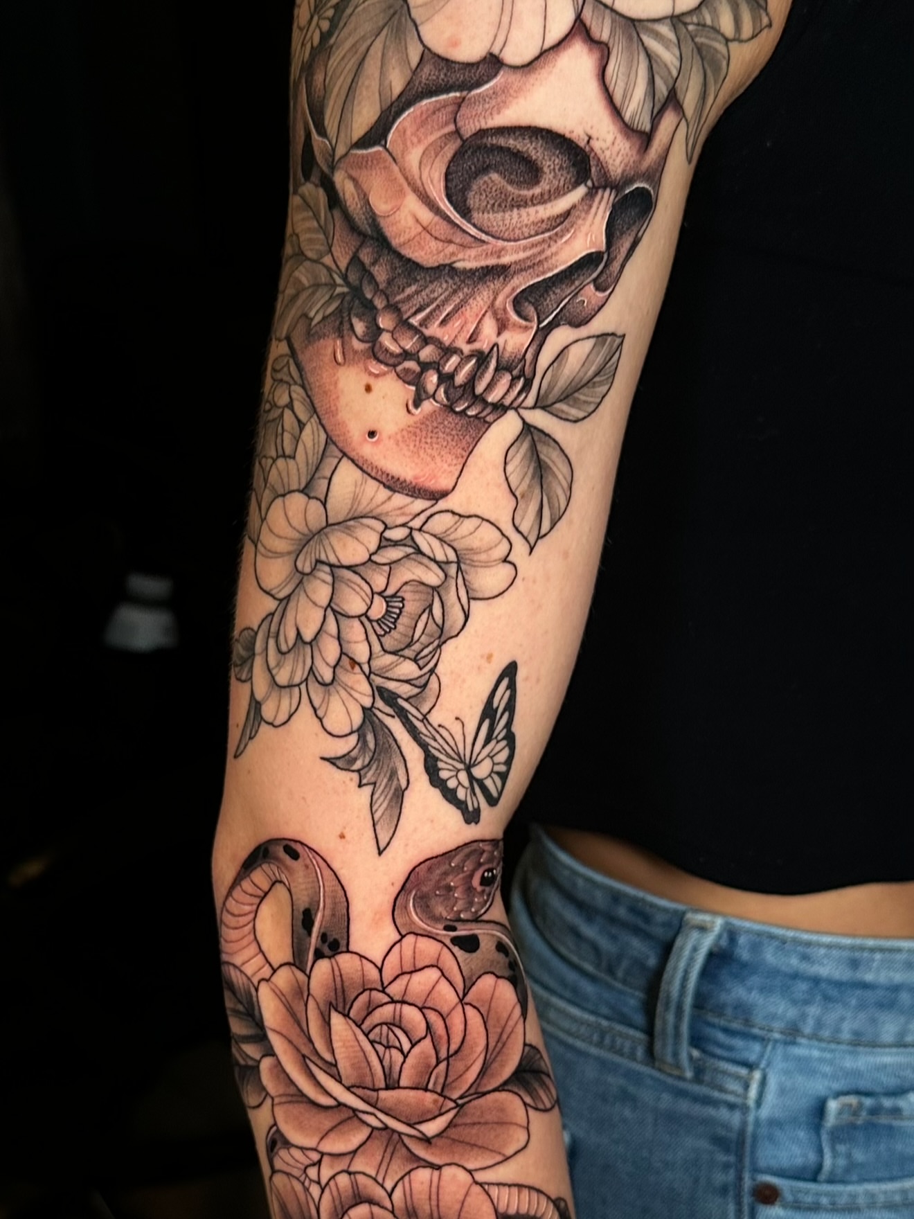 Skull and roses realism tattoo on the forearm by Beau Zeis