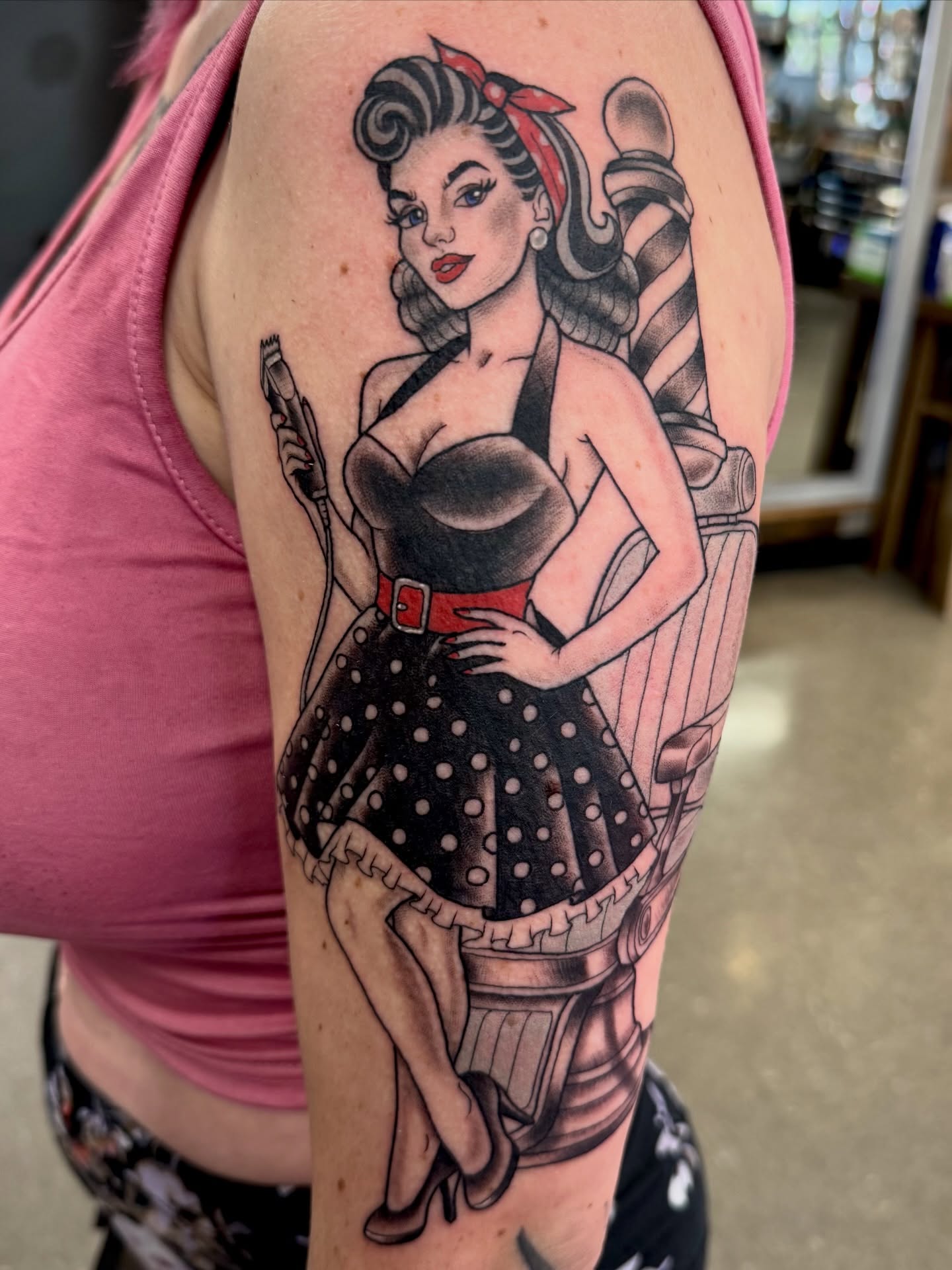 Pin-up girl American traditional tattoo on the upper arm by Samantha Jane