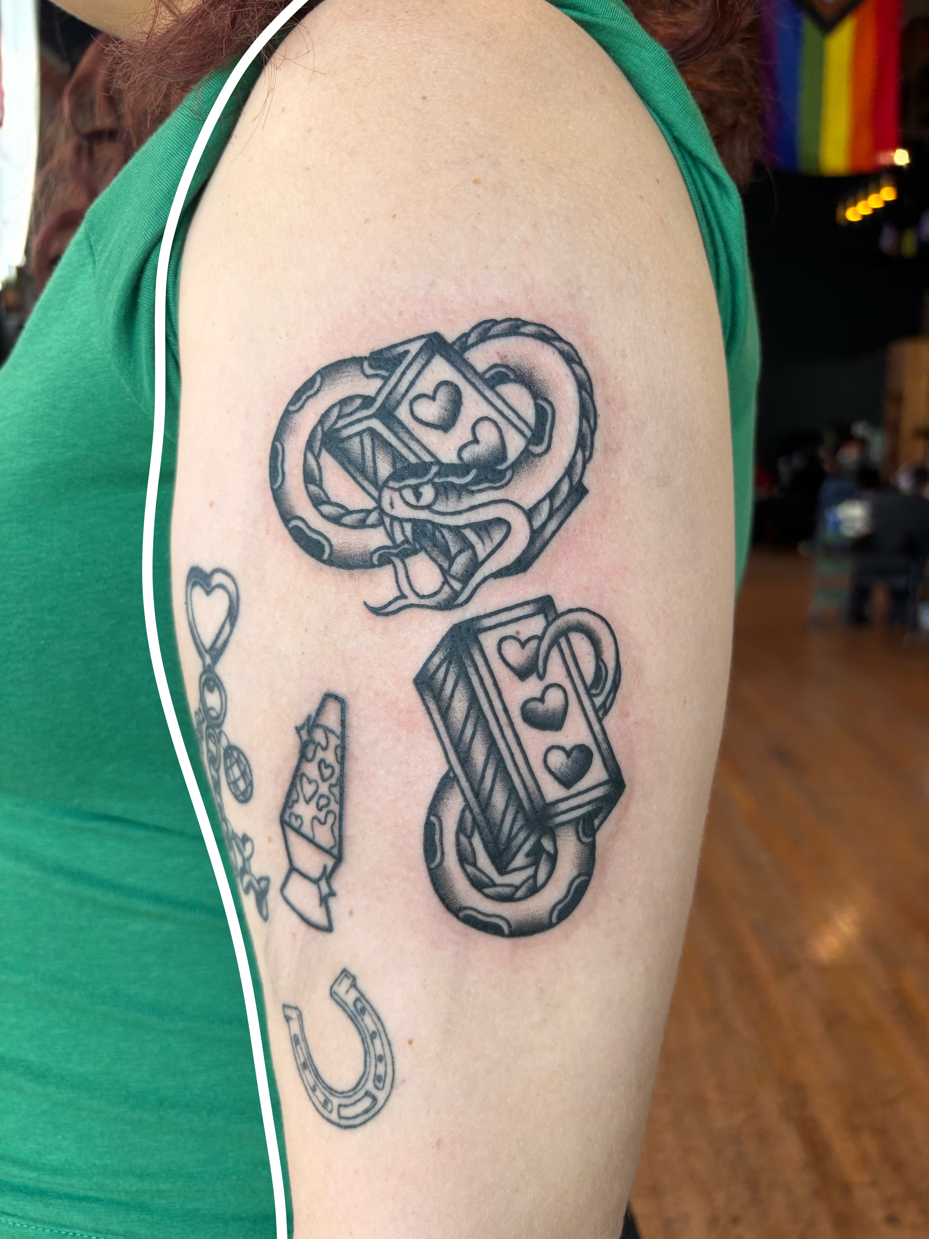 Snake and playing cards black and grey tattoo on the upper arm by Emmy Stepien