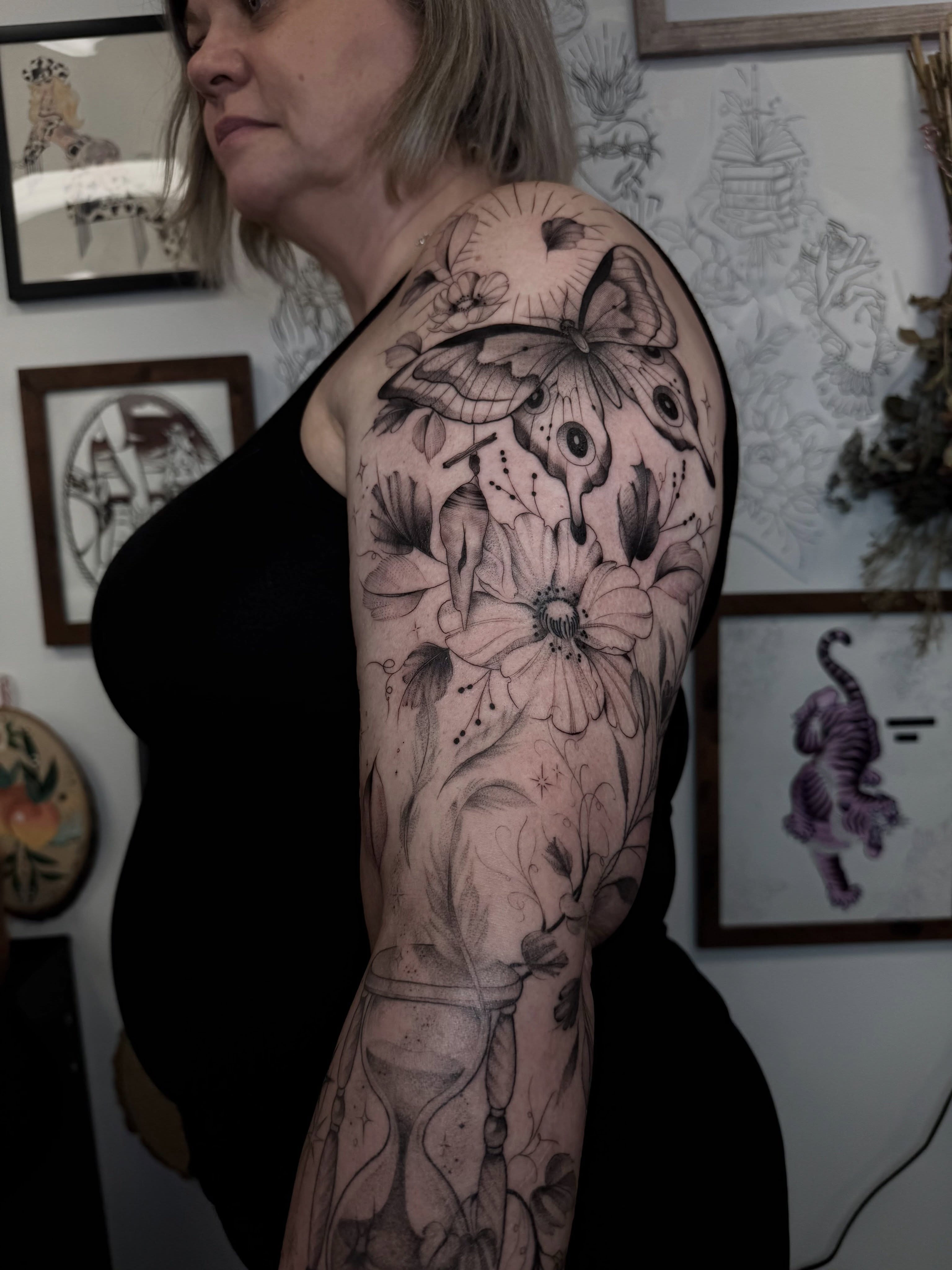Butterfly and flowers realism tattoo on the upper arm by Chloe