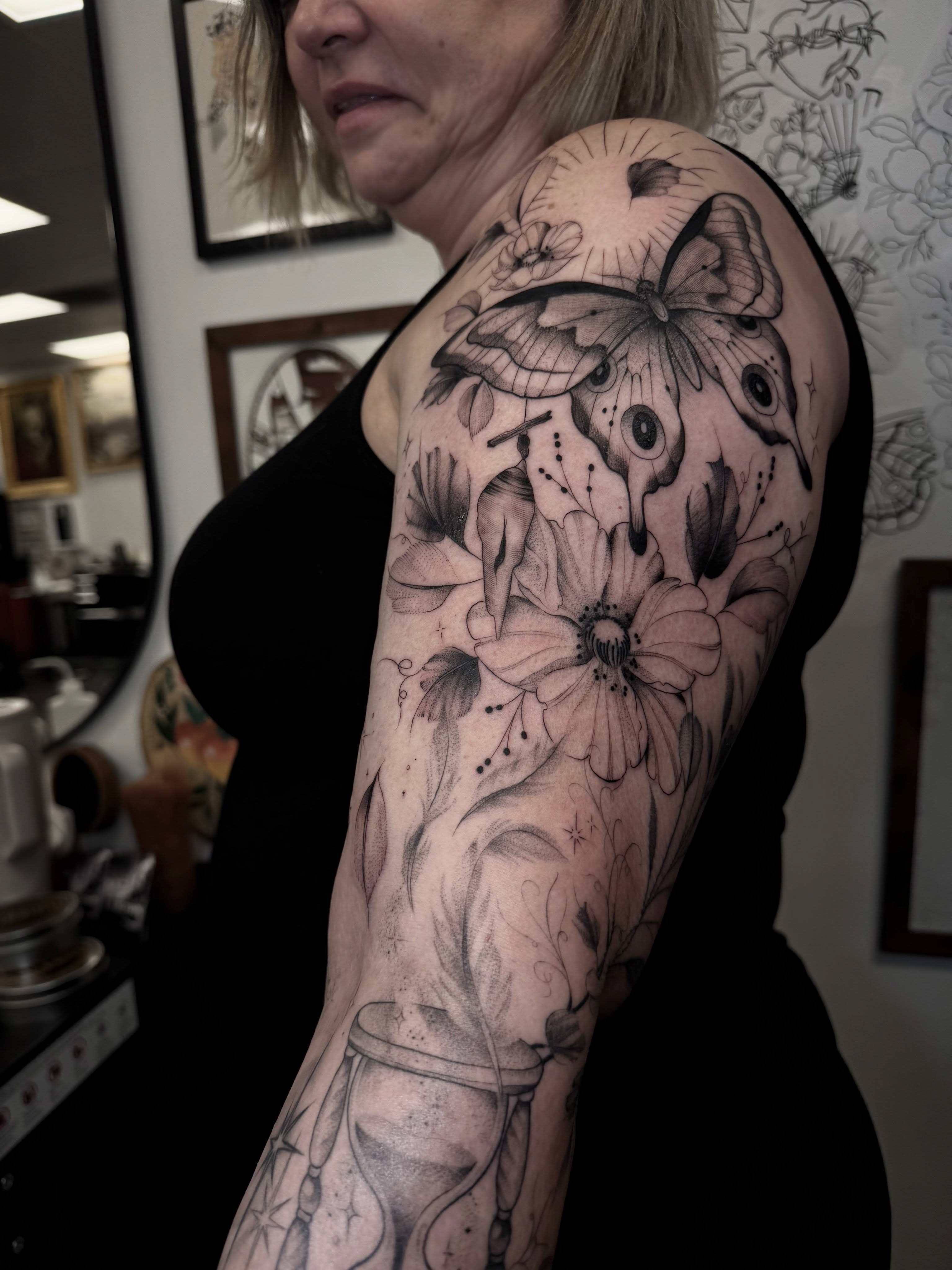 Butterfly and flowers realism tattoo on the upper arm by Chloe
