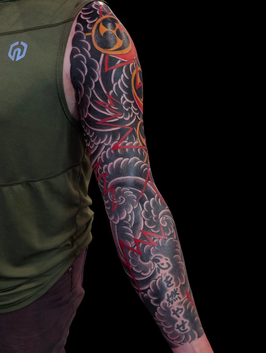 Dragon and clouds with Japanese script Japanese tattoo on the upper arm by Angela Mukai