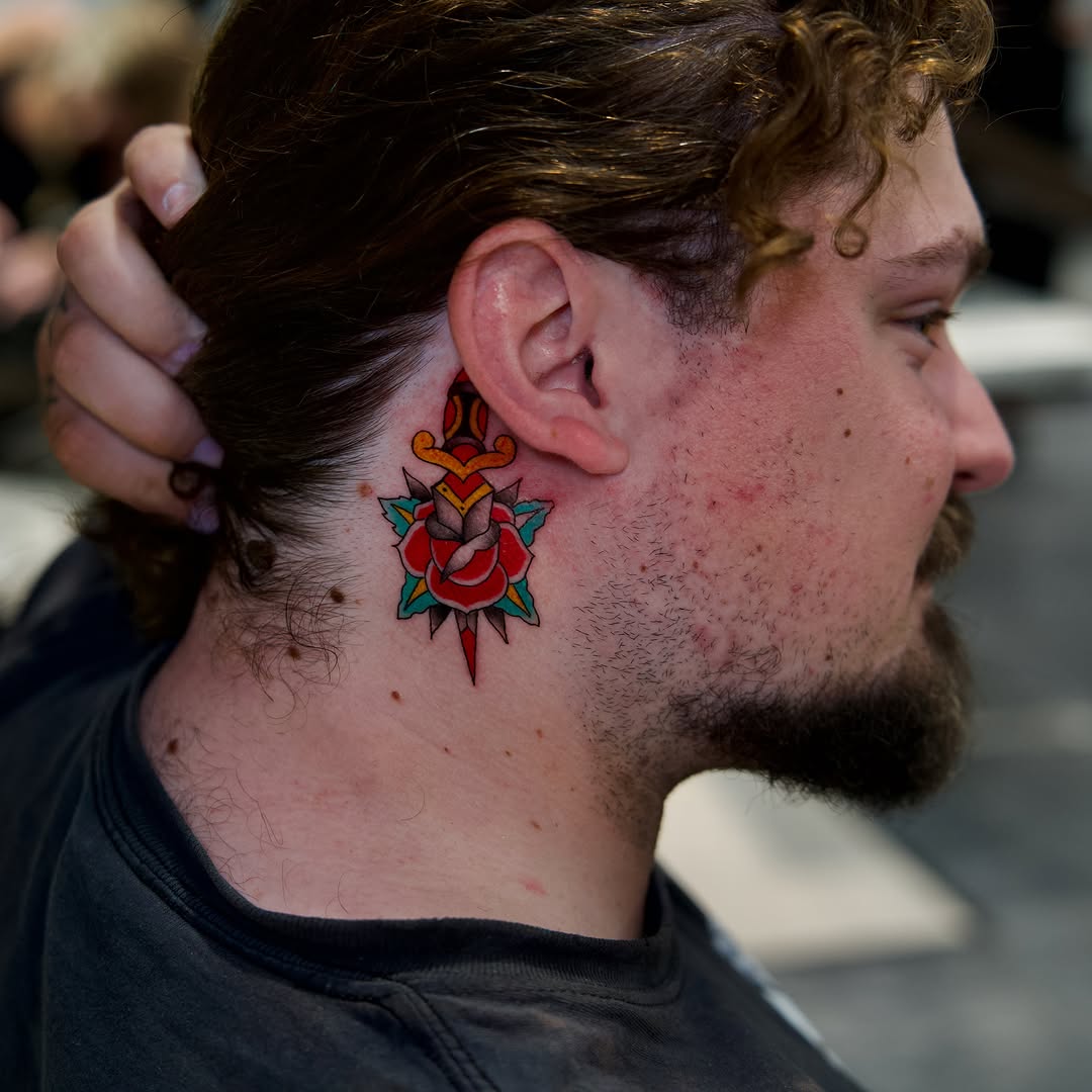 Flower and heart American traditional tattoo on the neck by Raven Wood