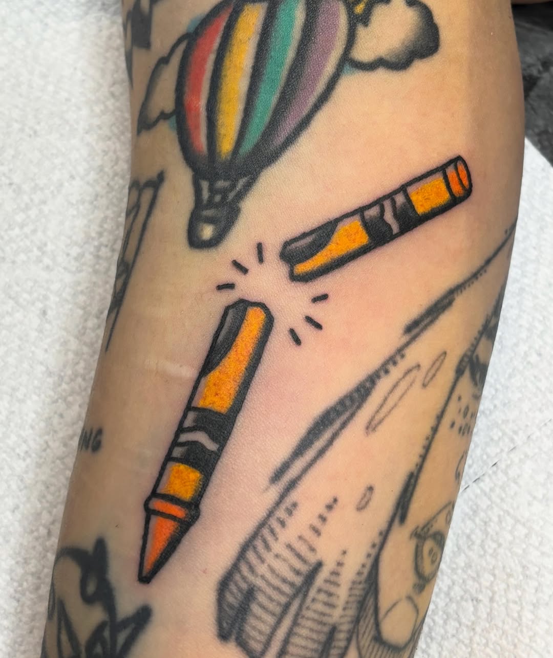 Crayons and hot air balloon American traditional tattoo on the forearm by @rutattoos