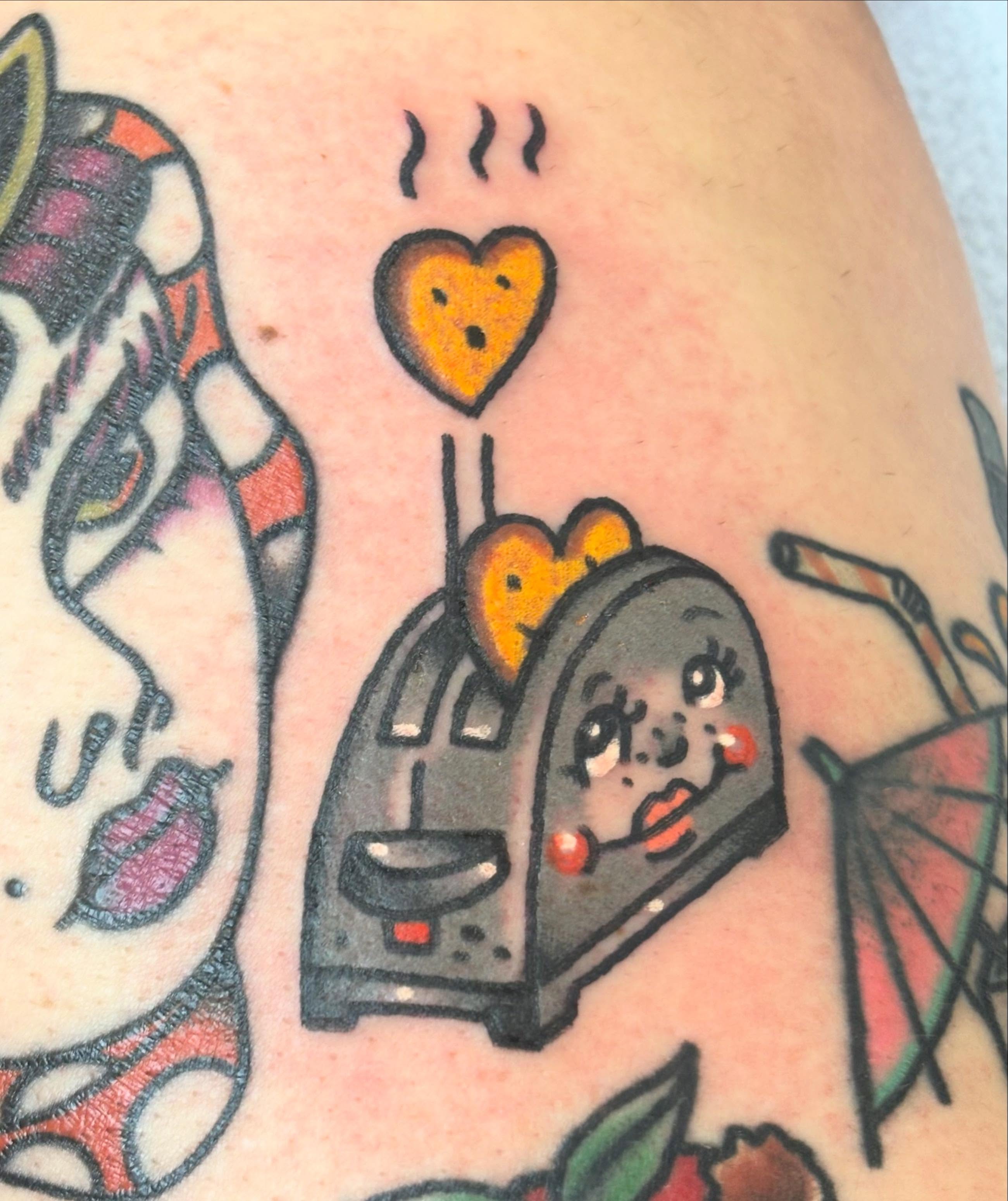Toaster with heart American traditional tattoo on the upper arm by @rutattoos