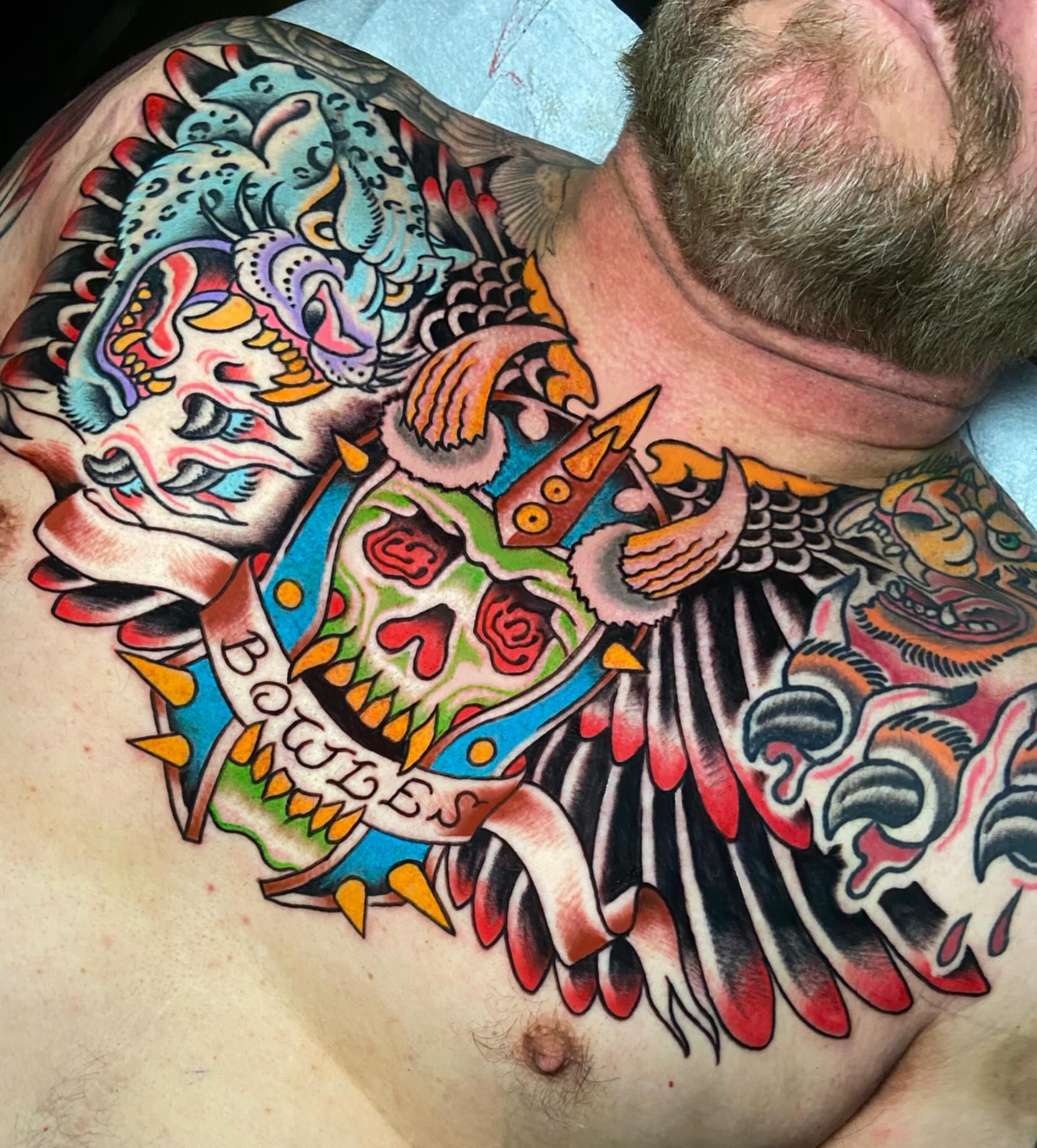 Skull and wings American traditional tattoo on the chest by Chris Bishop