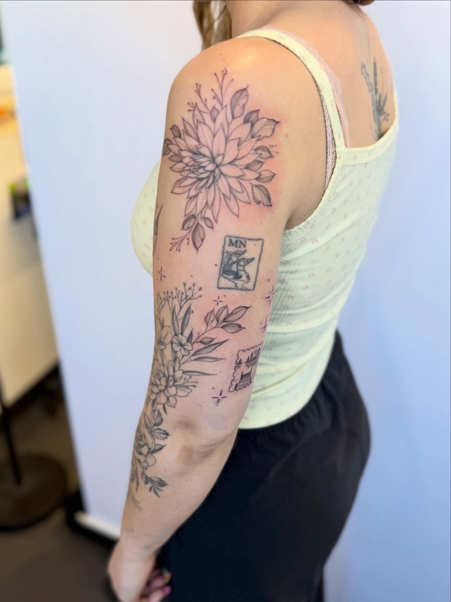 Floral arrangement black and grey tattoo on the upper arm by Peter Harren