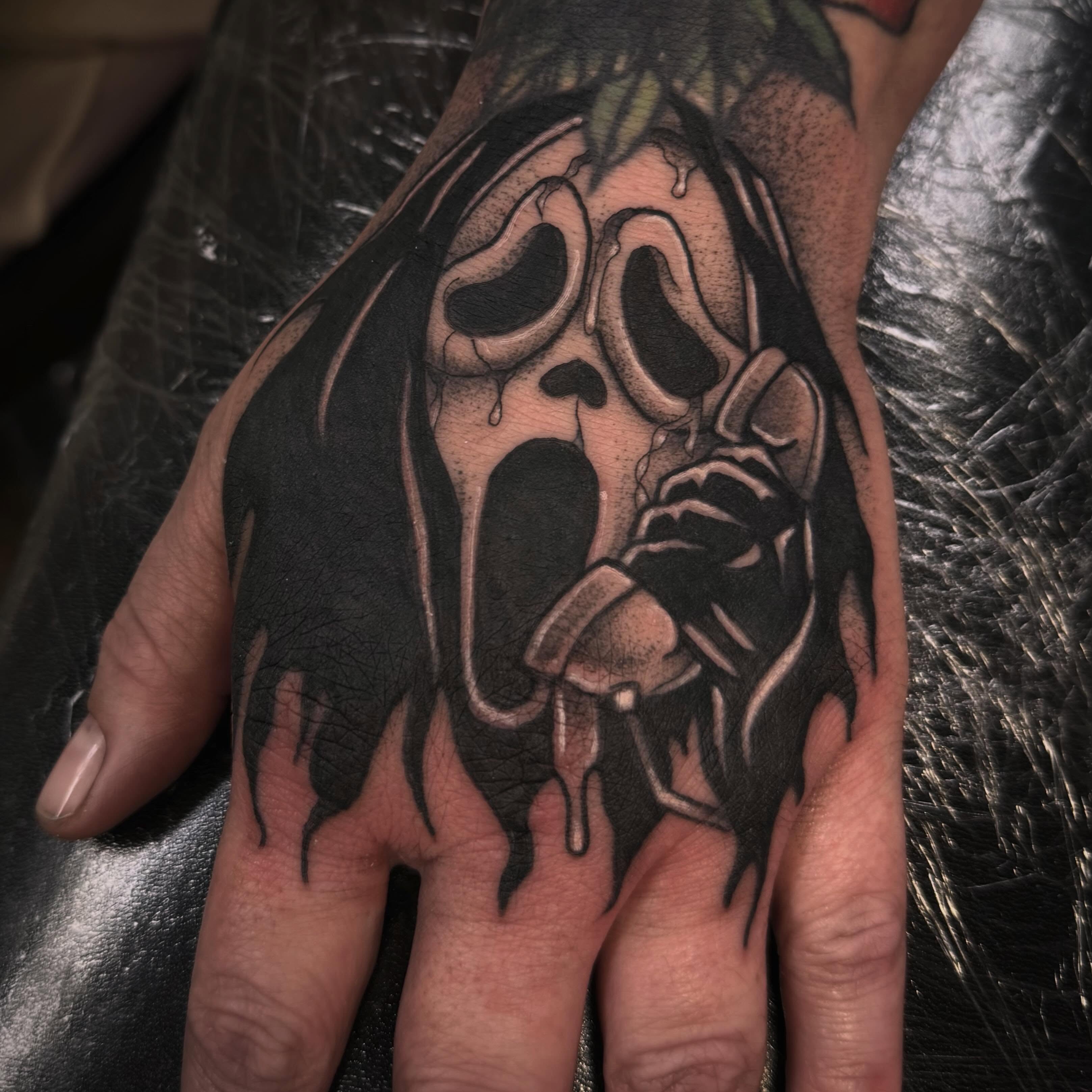 Scream mask dark realism tattoo on the hand by Sarah Foltz