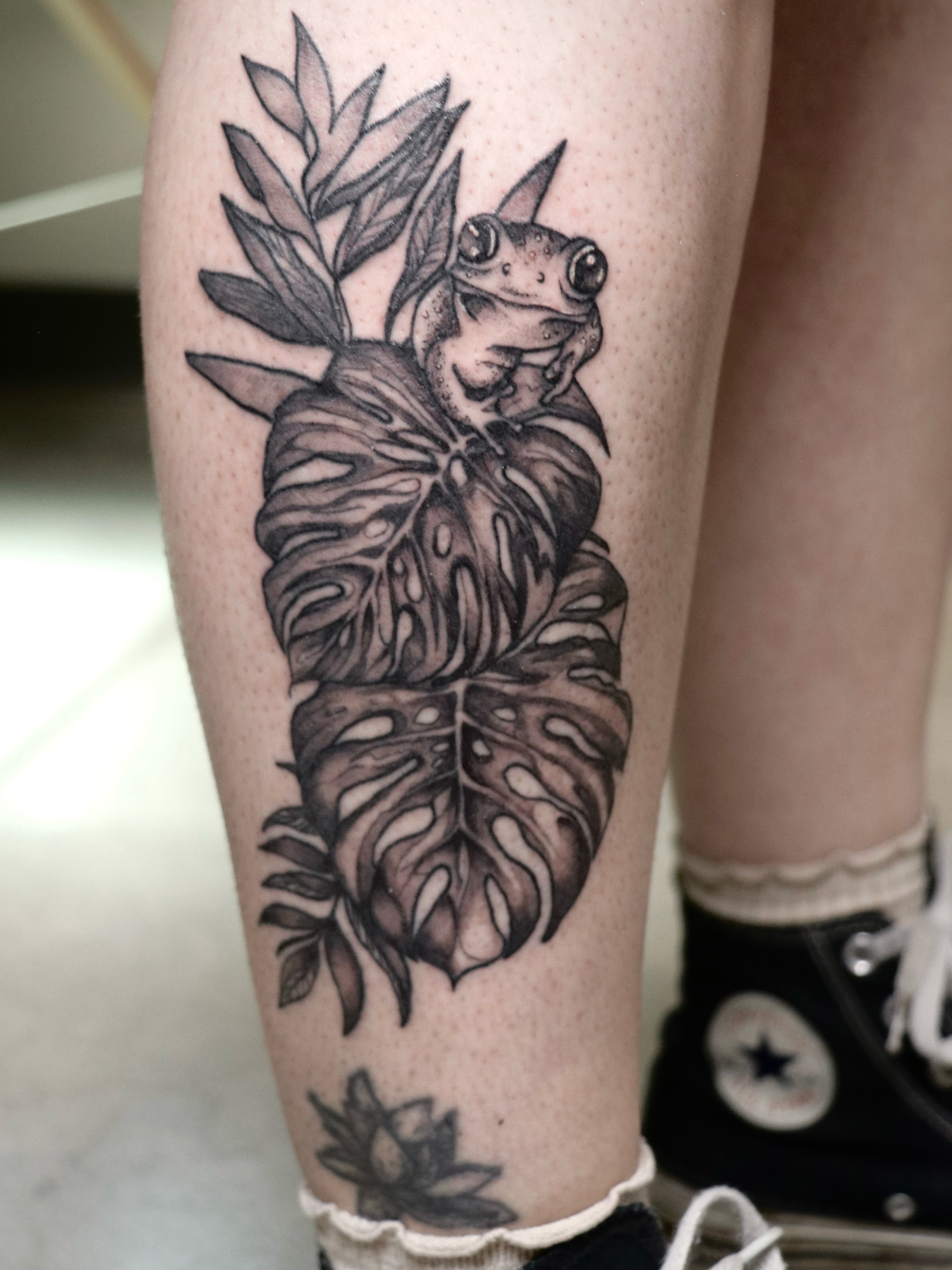 Frog and monstera leaves realism tattoo on the calf by Love 🥀 222
